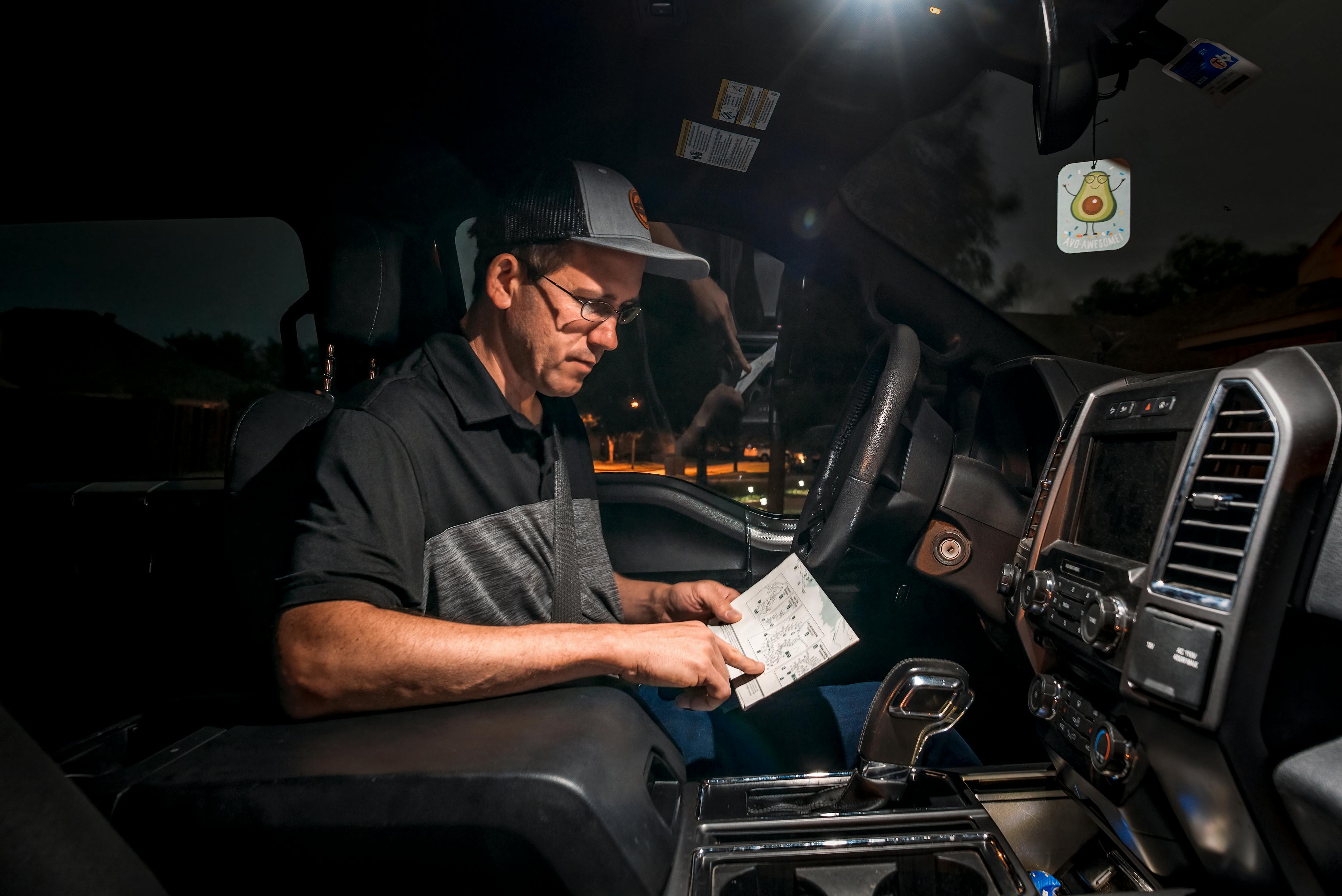 Jason Takacs looks at a document in his truck.