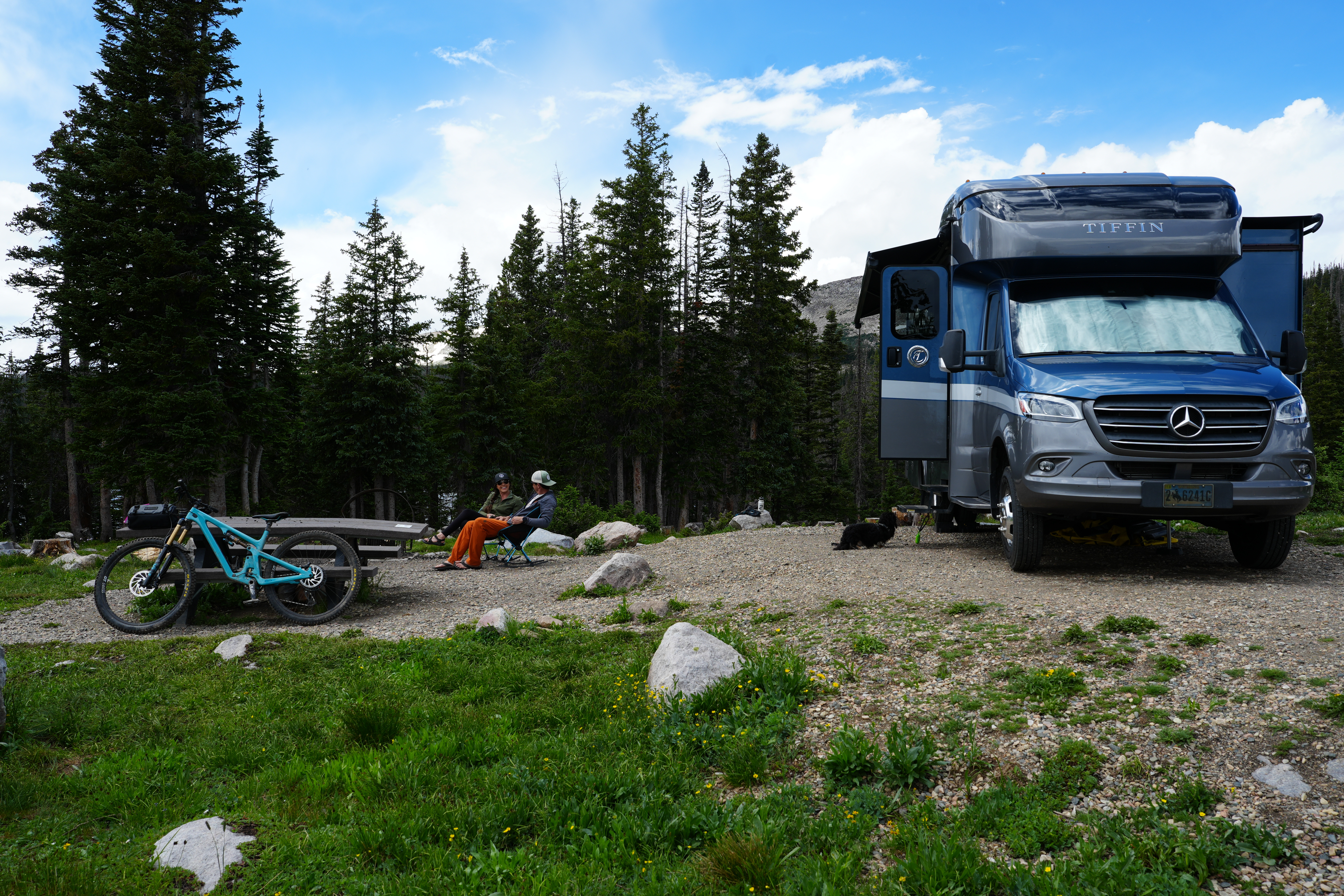 The Bauers sit beside their Tiffin Wayfarer Class C Motorhome in Medicine Bow-Routt National Forest