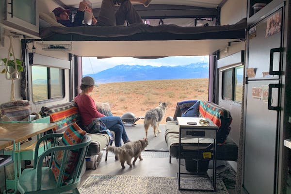Amy Rekart looks out the back of her Cruiser Stryker toy hauler while her husband reads on the above bunk.