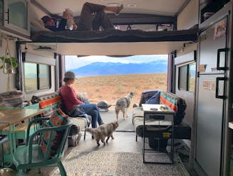Amy Rekart looks out the back of her Cruiser Stryker toy hauler while her husband reads on the above bunk.
