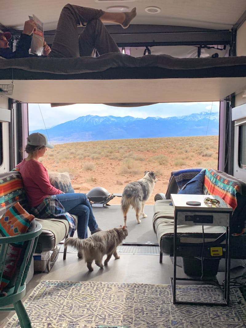 Amy Rekart looks out the back of her Cruiser Stryker toy hauler while her husband reads on the above bunk.