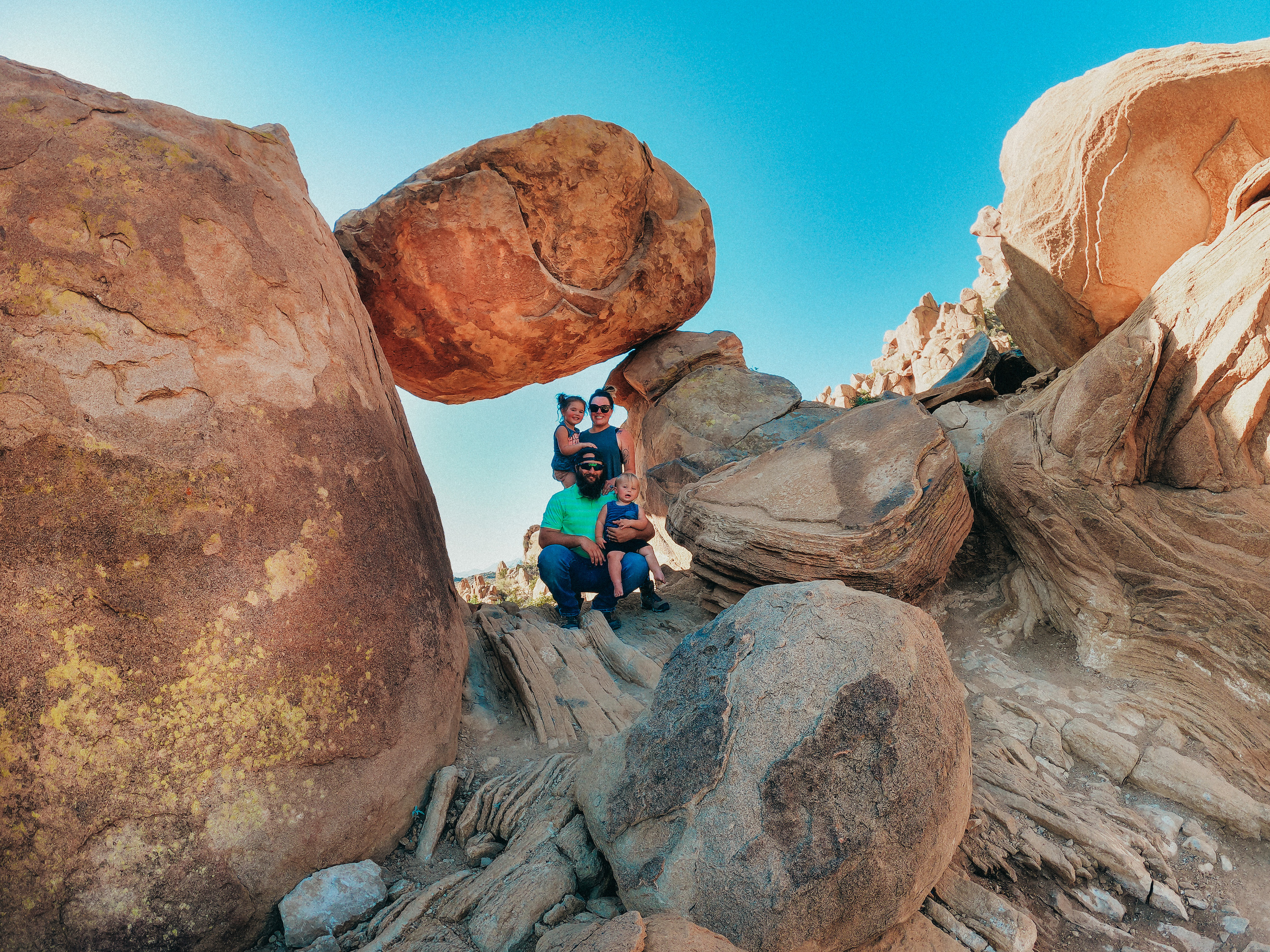 Sammy Seles' family poses on a hike through the desert with large rocks.
