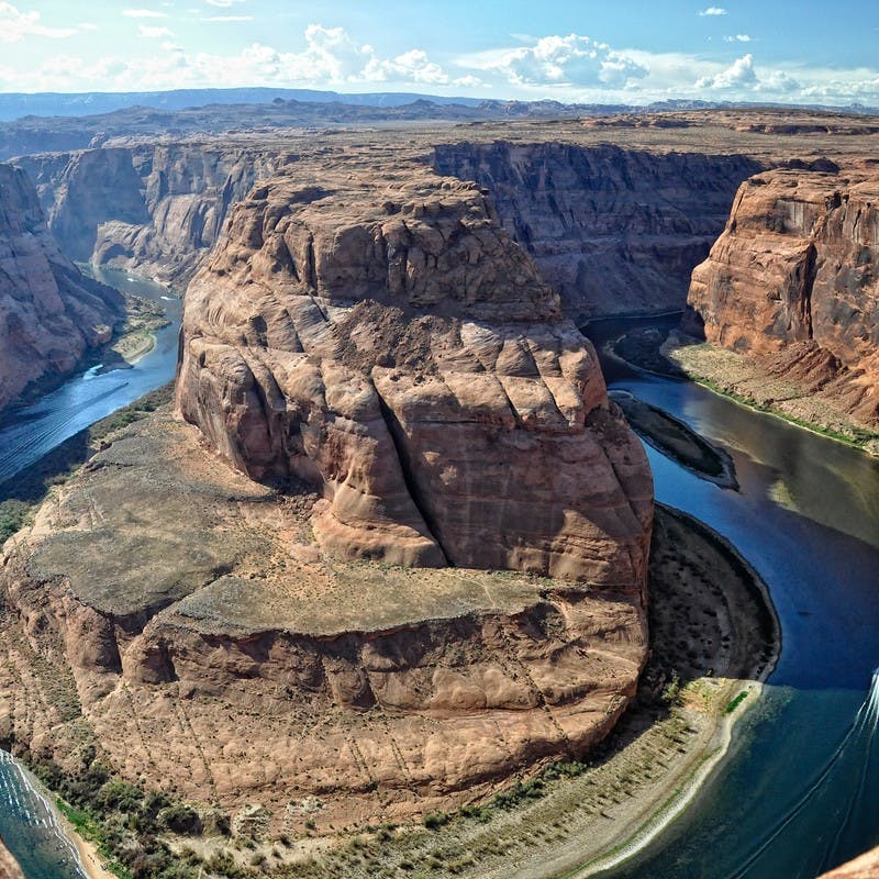 An overhead shot of rock canyons formed by the Colorado River that cuts between them. 
