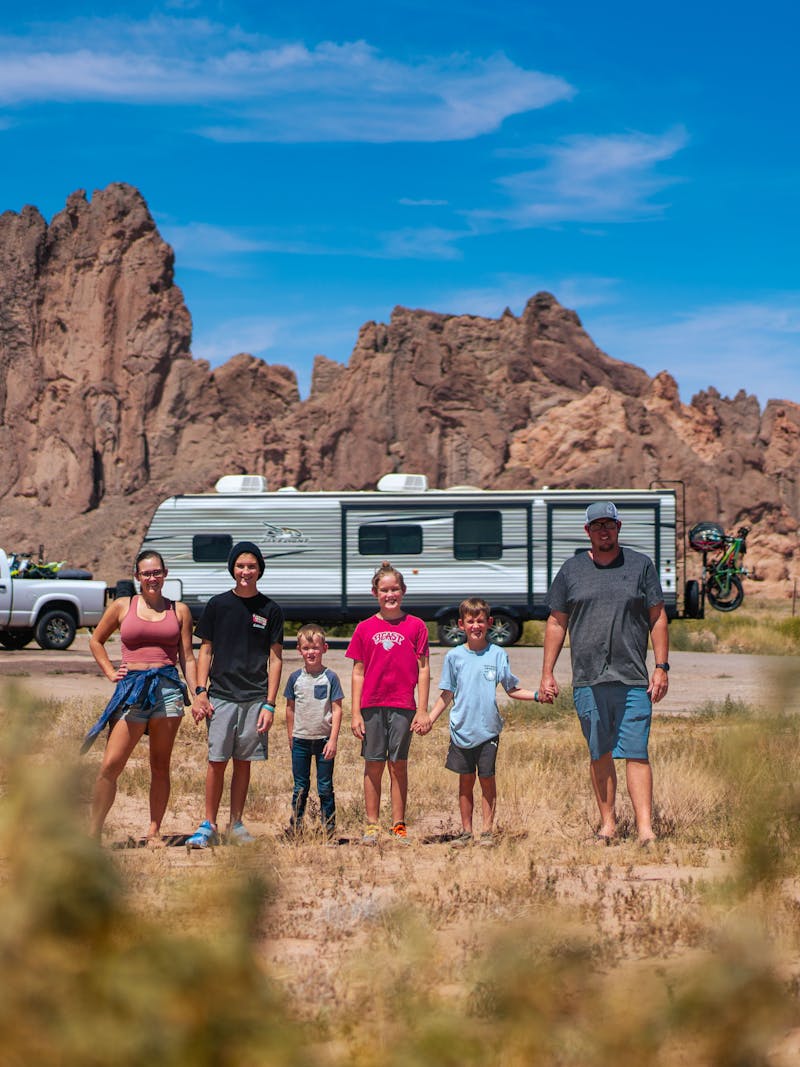 The Renee Tilby family posed in front of their Jayco Jay Flight Travel Trailer in the desert