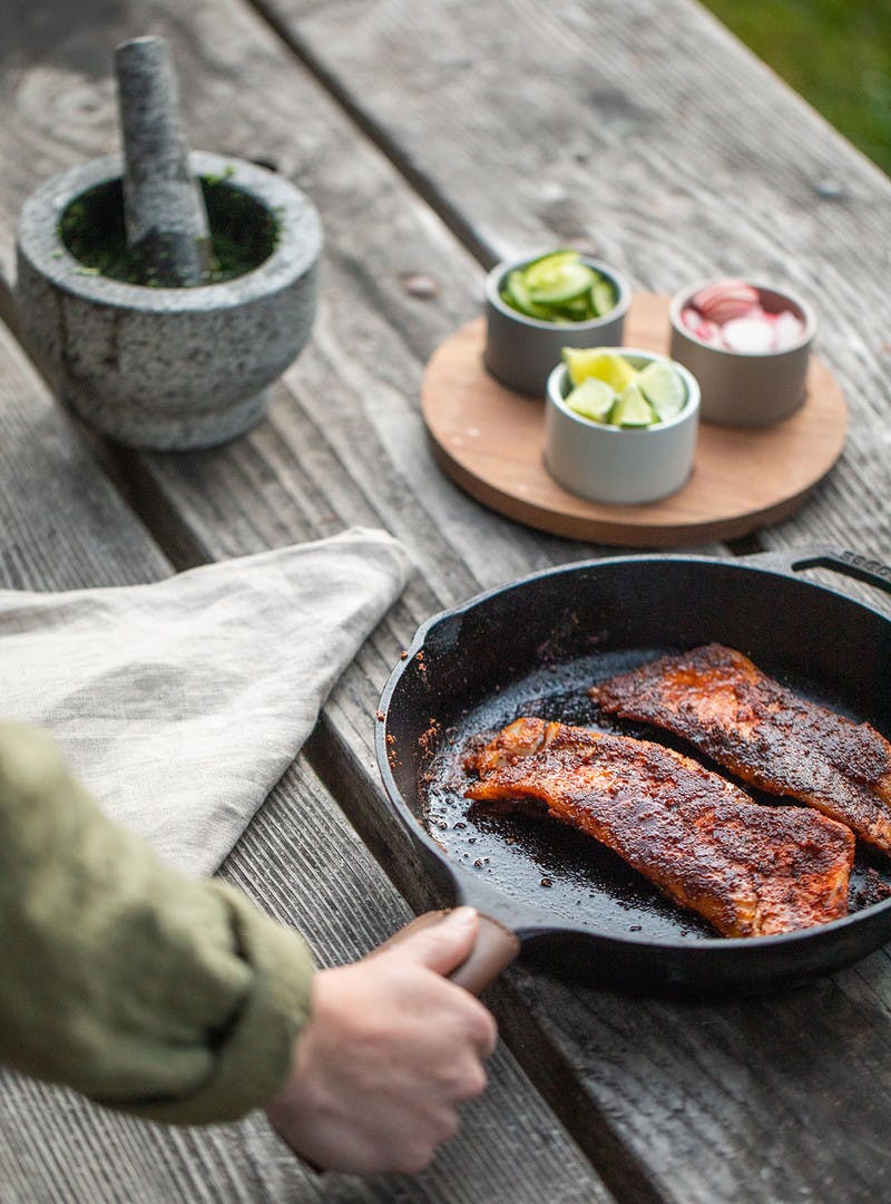 Cooked Rockfish in a pan sitting on a picnic table.