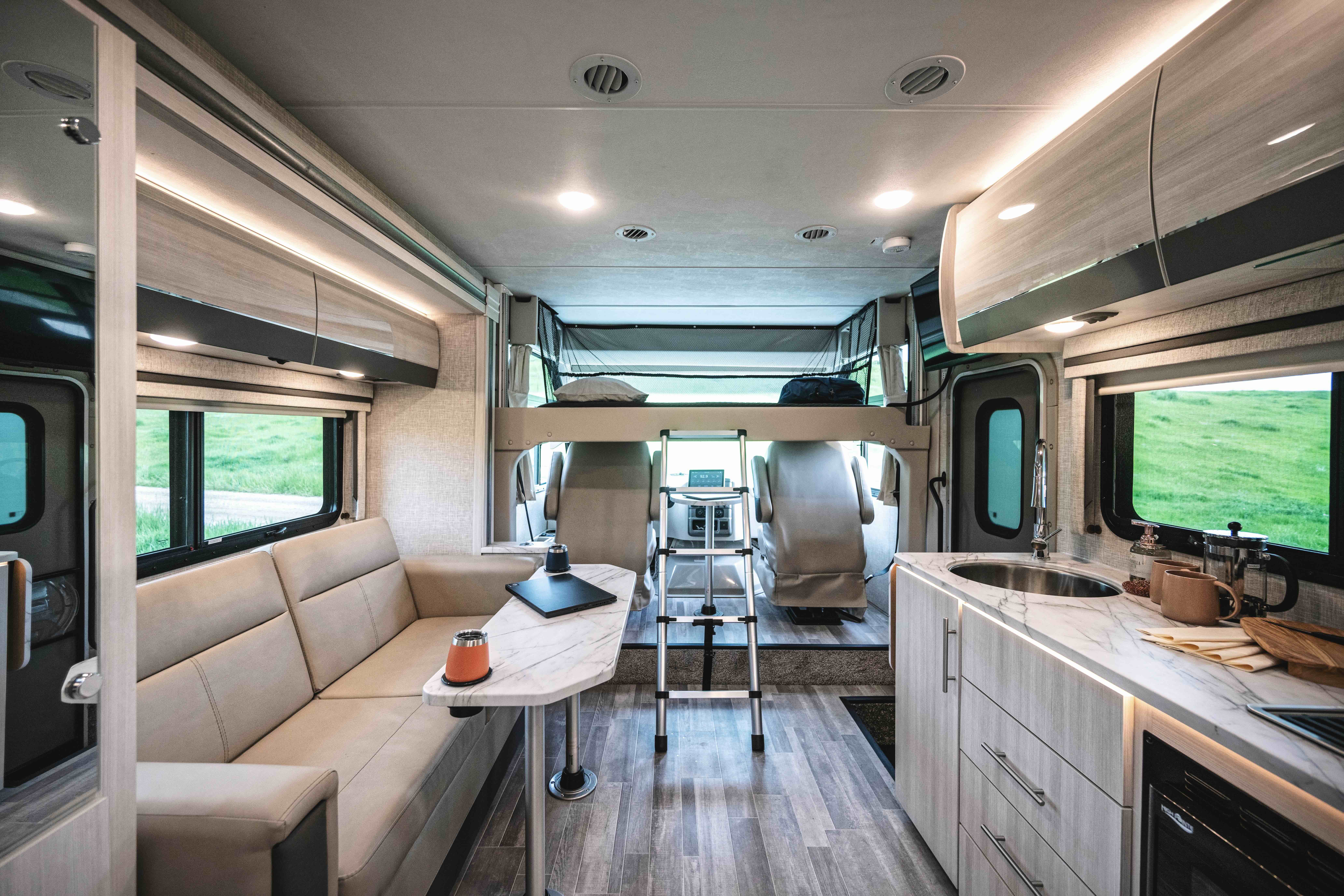 The interior of a Class A Motorhome, featuring the living area, kitchen, bunk, and driving dashboard.