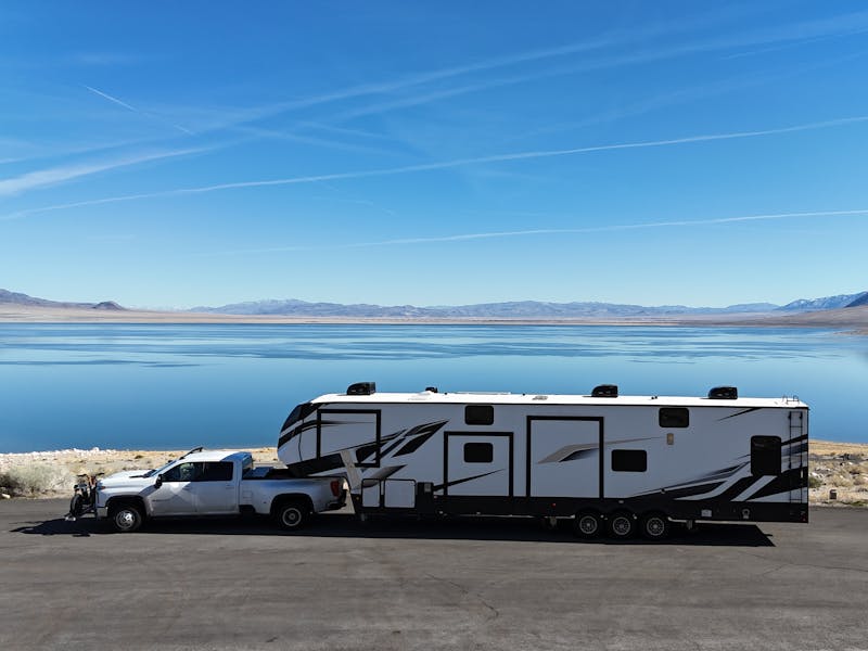 Dutchmen Voltage Triton toy hauler RV parked in front of a lake