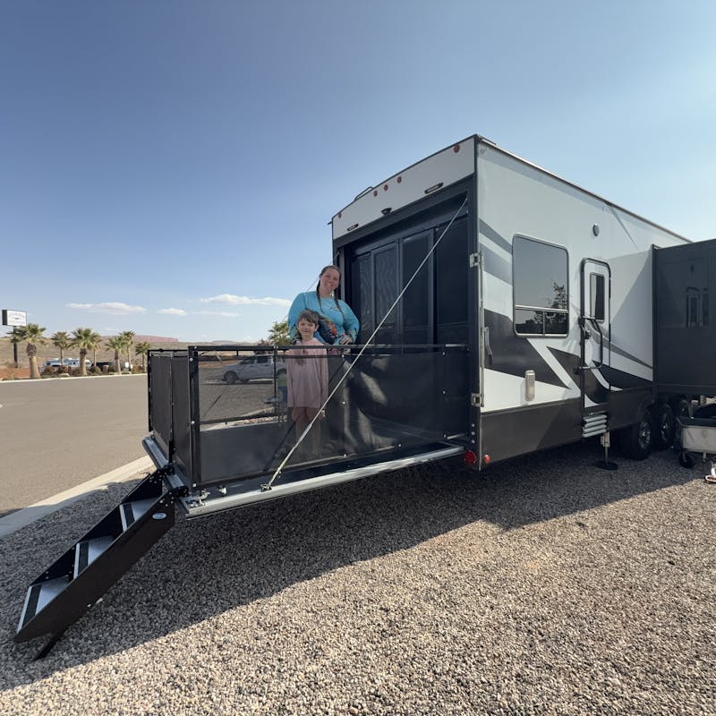 Jessica White and her son standing on the back patio of their Dutchmen Voltage Triton