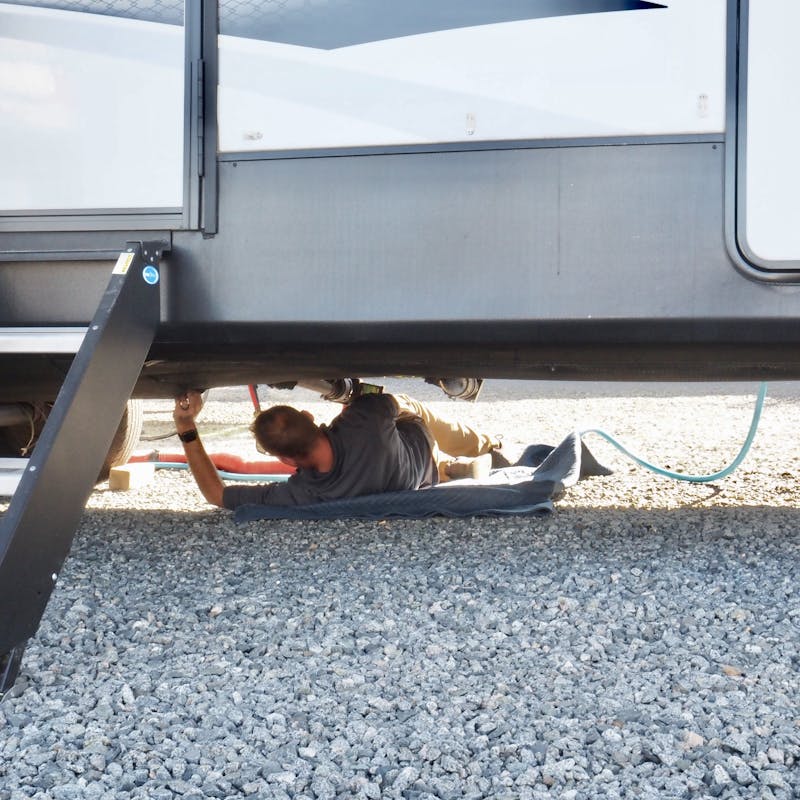 A THOR mobile RV repair technician working on Bailey and Nicole Damberg's RV