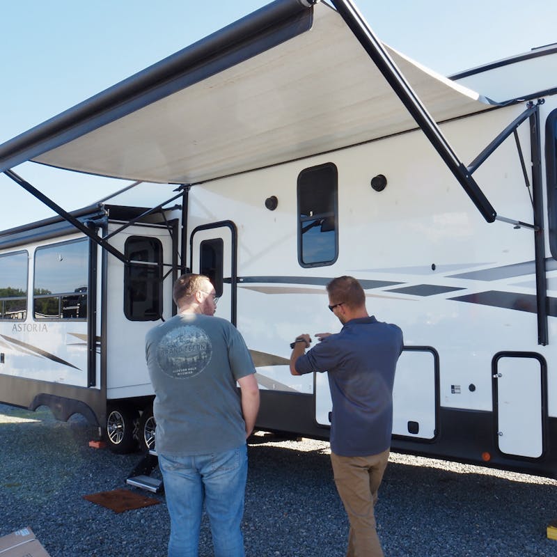 A THOR's mobile RV repair technician chatting with Bailey Damberg in front of his RV
