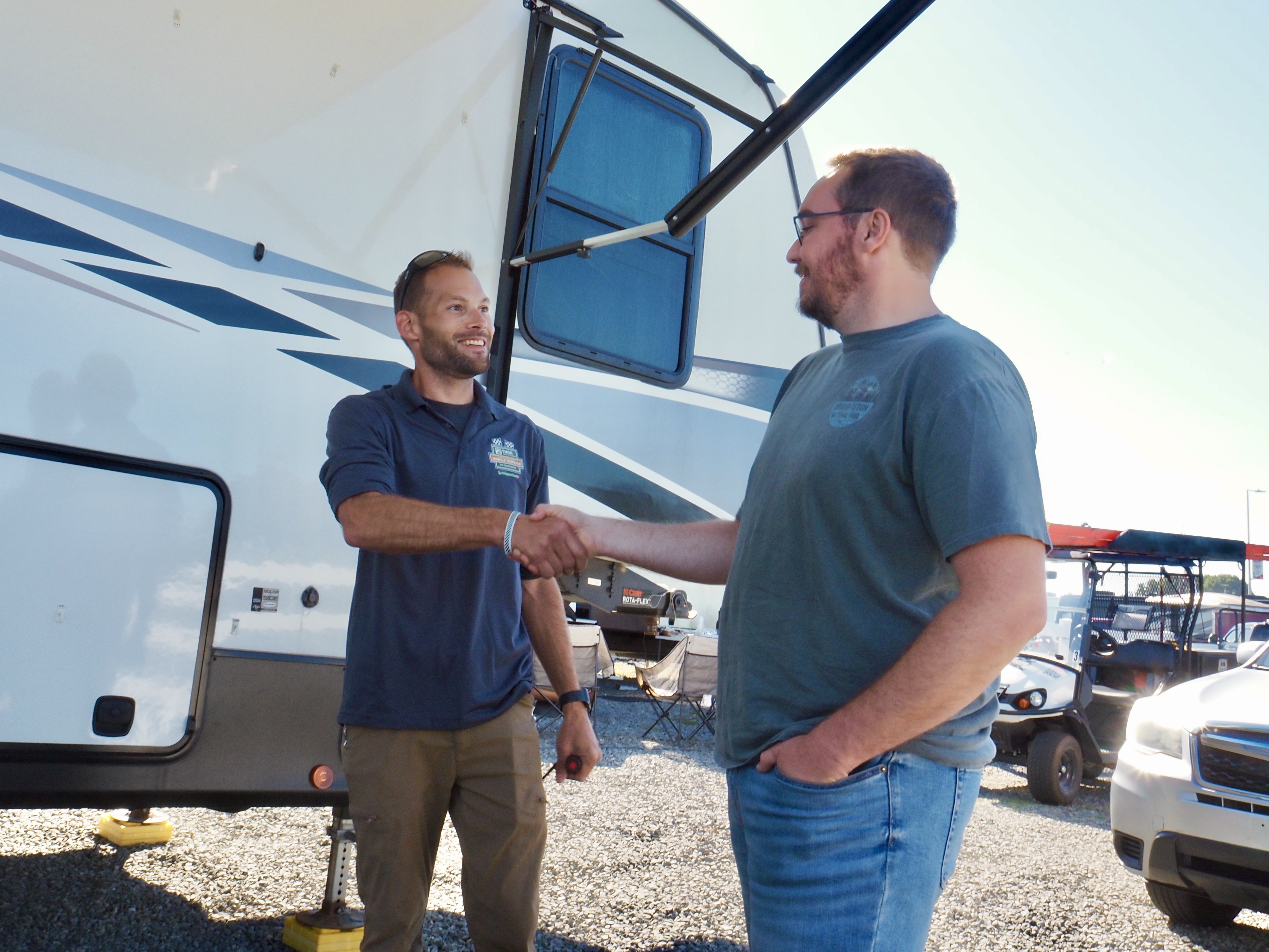 A THOR's mobile RV repair technician shaking Bailey Damberg's hand in front of their RV