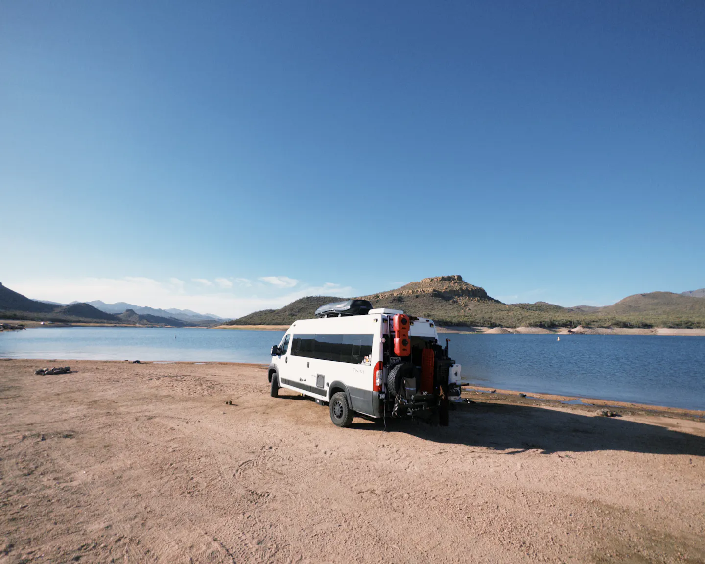 a camper van boondocking next to a lake 