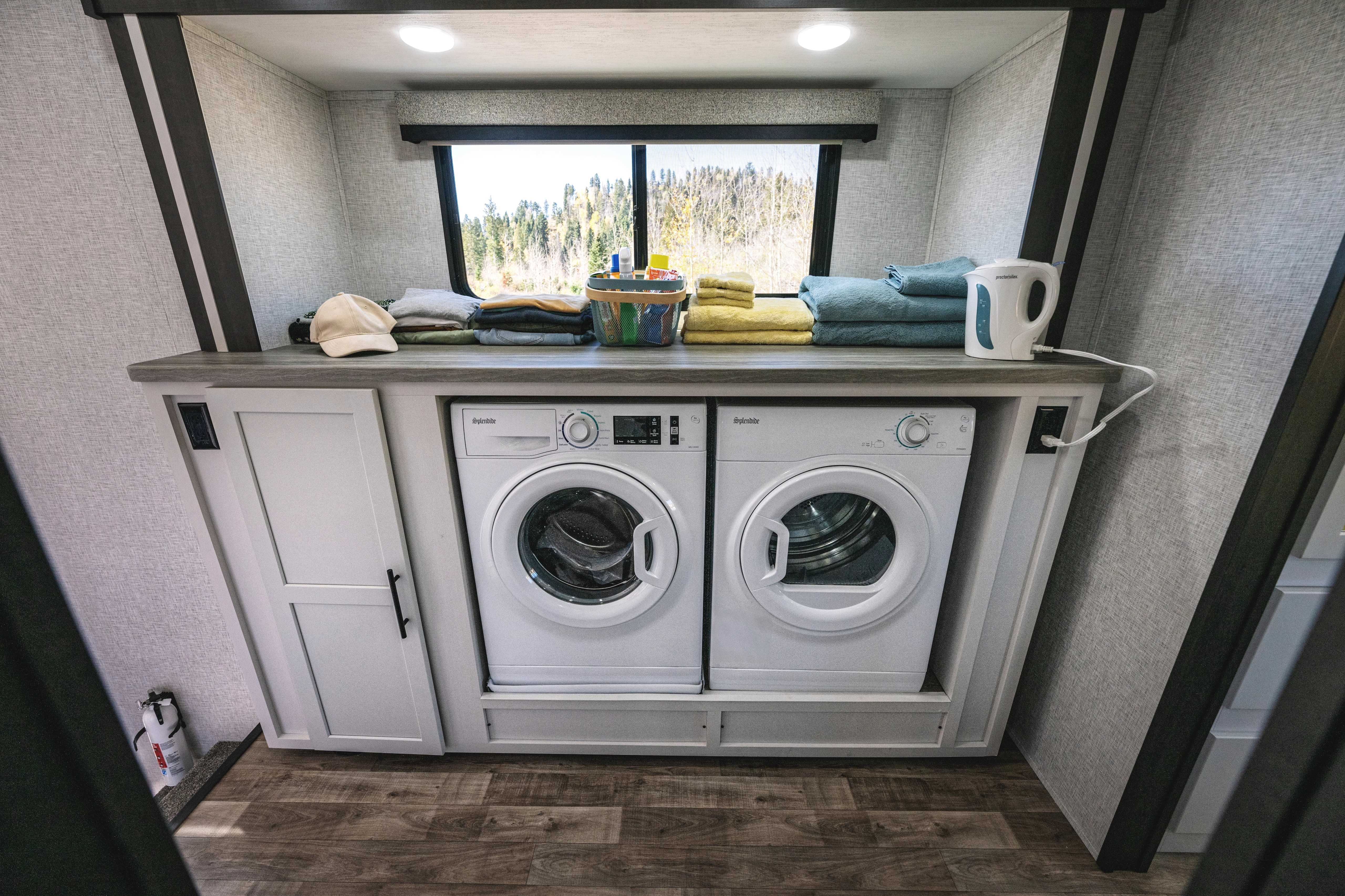 A washer and dryer laundry unit inside of a Crossroads Hampton destination trailer