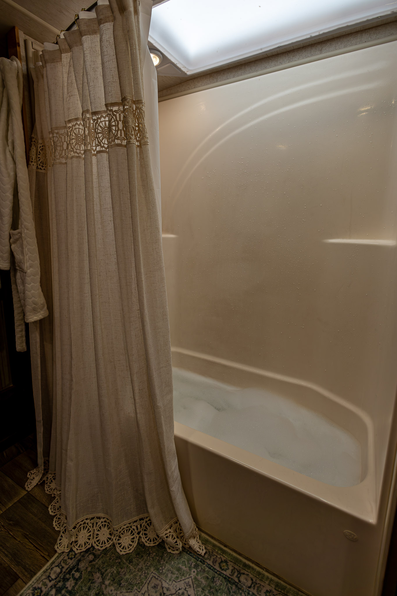 The tub inside of a toy hauler RV filled as a bubble bath 