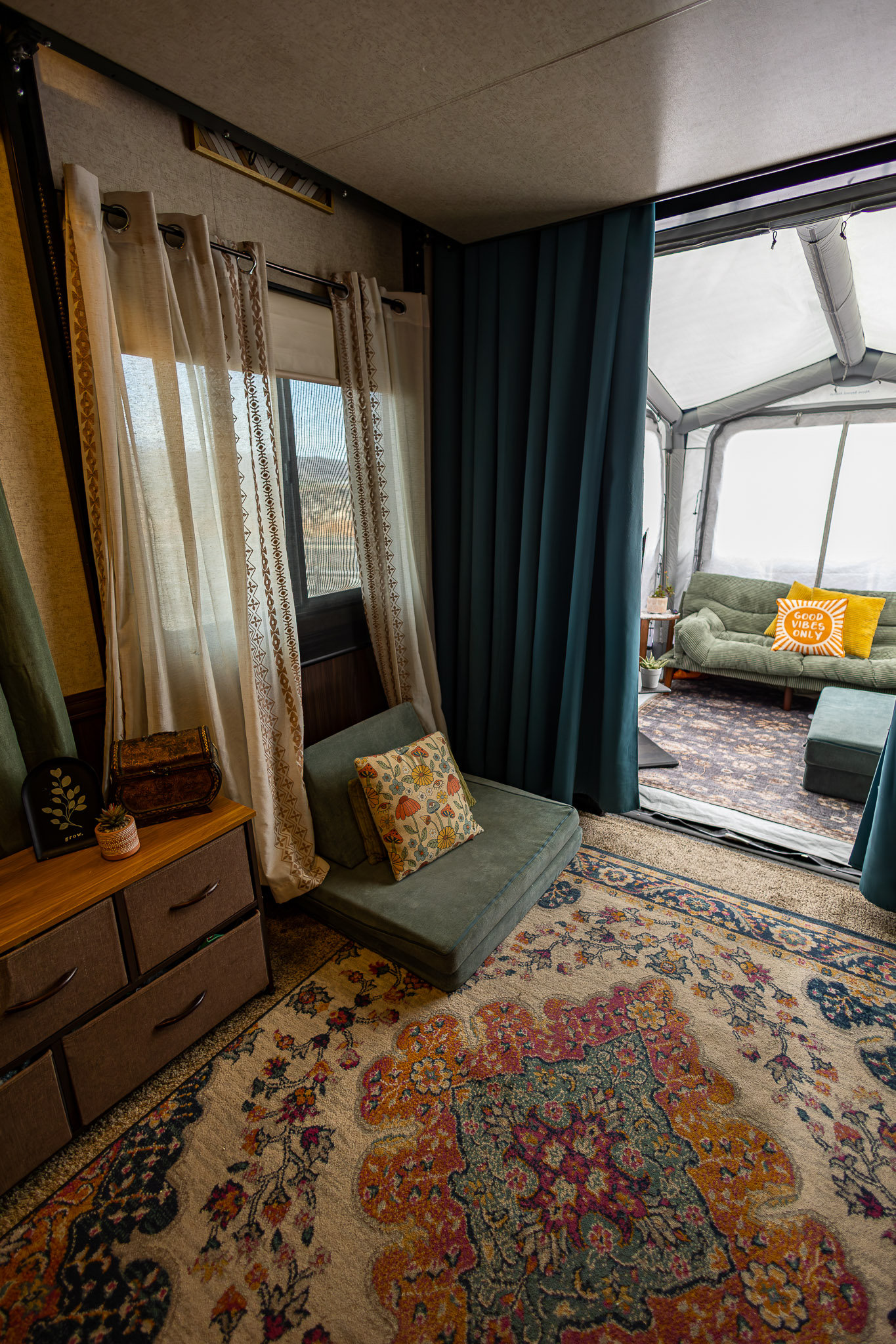 the garage area of a toy hauler with a cozy rug, curtains and chair 