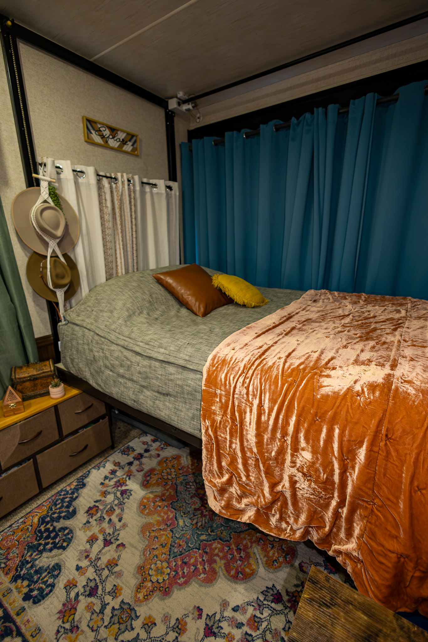 A bunked in the garage of a toy hauler RV with cozy blankets and pillows