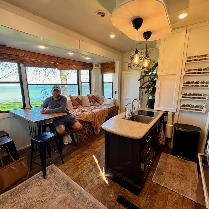 Lucas Lahr sits at the dinnette inside his heartland torque toy hauler