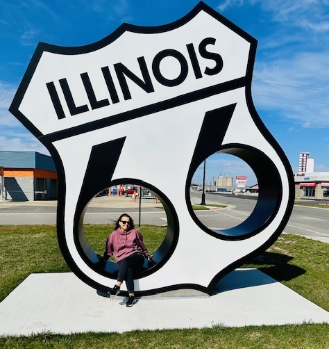 A woman sitting inside the Route 66 sign in Illinois 