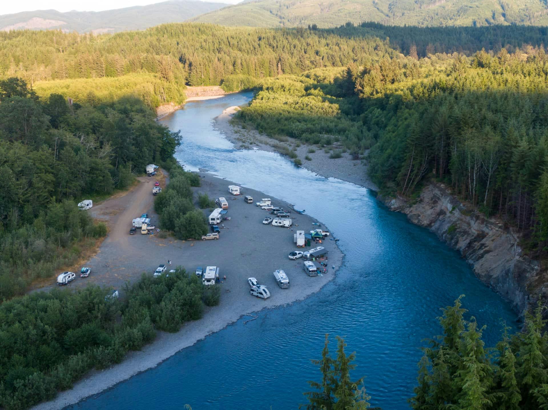 Karen Blue's Airstream parked by a river with other RVs.