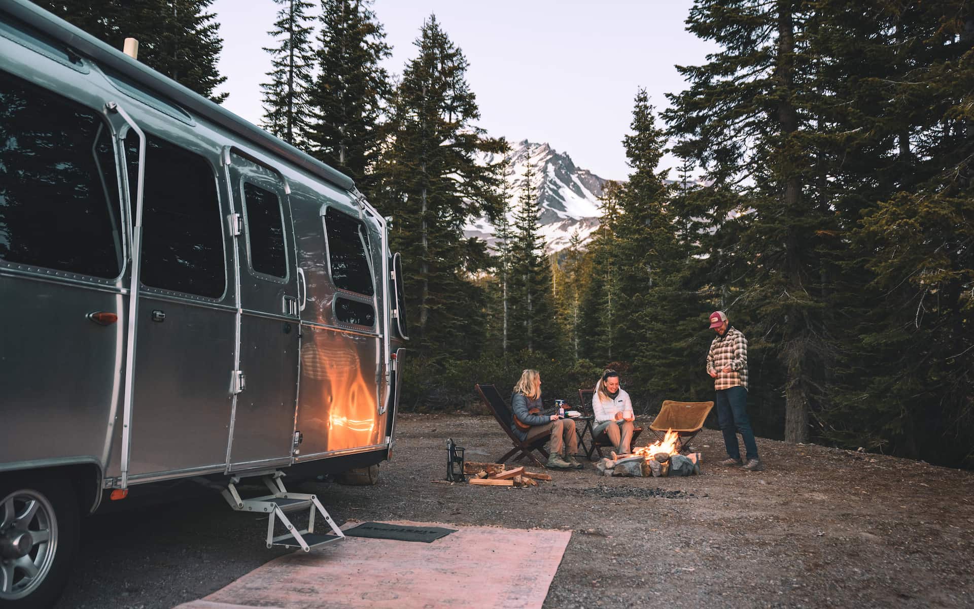 Karen Blue and her family sitting around a fire while boondocking in a forest.