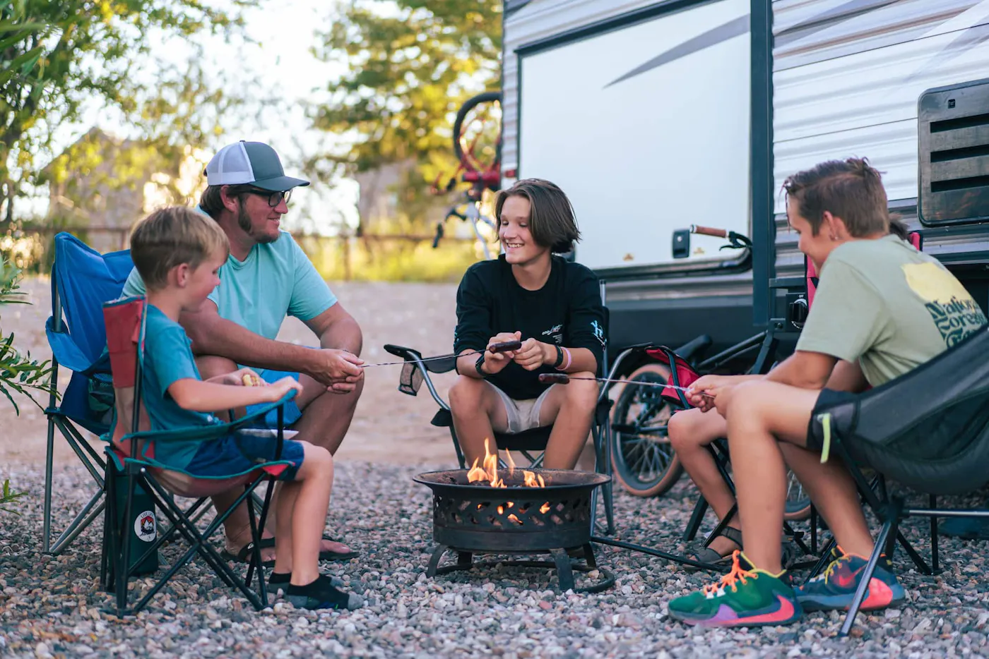 The Renee Tilby family sitting around a campfire outside of their Jayco Jay Flight Travel Trailer.