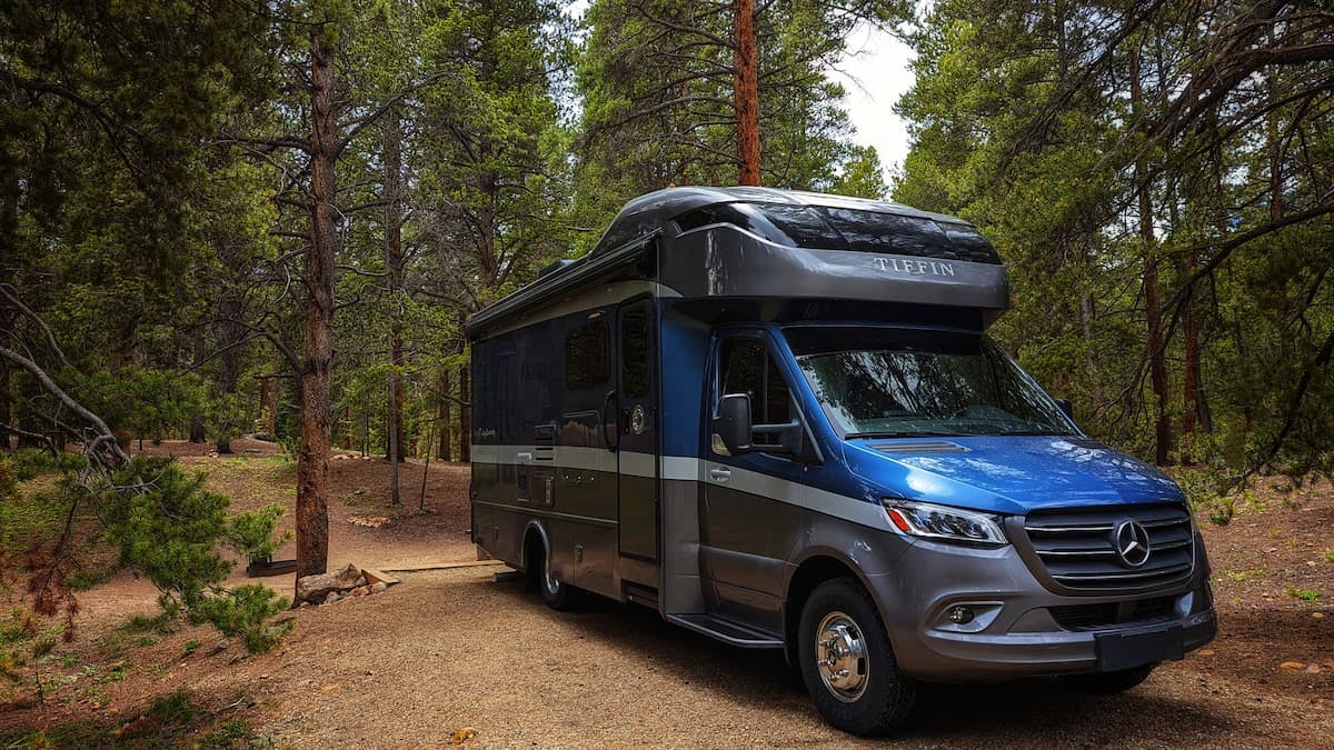 Dustin and Sarah Bauer's RV parked at a campsite in a forest.