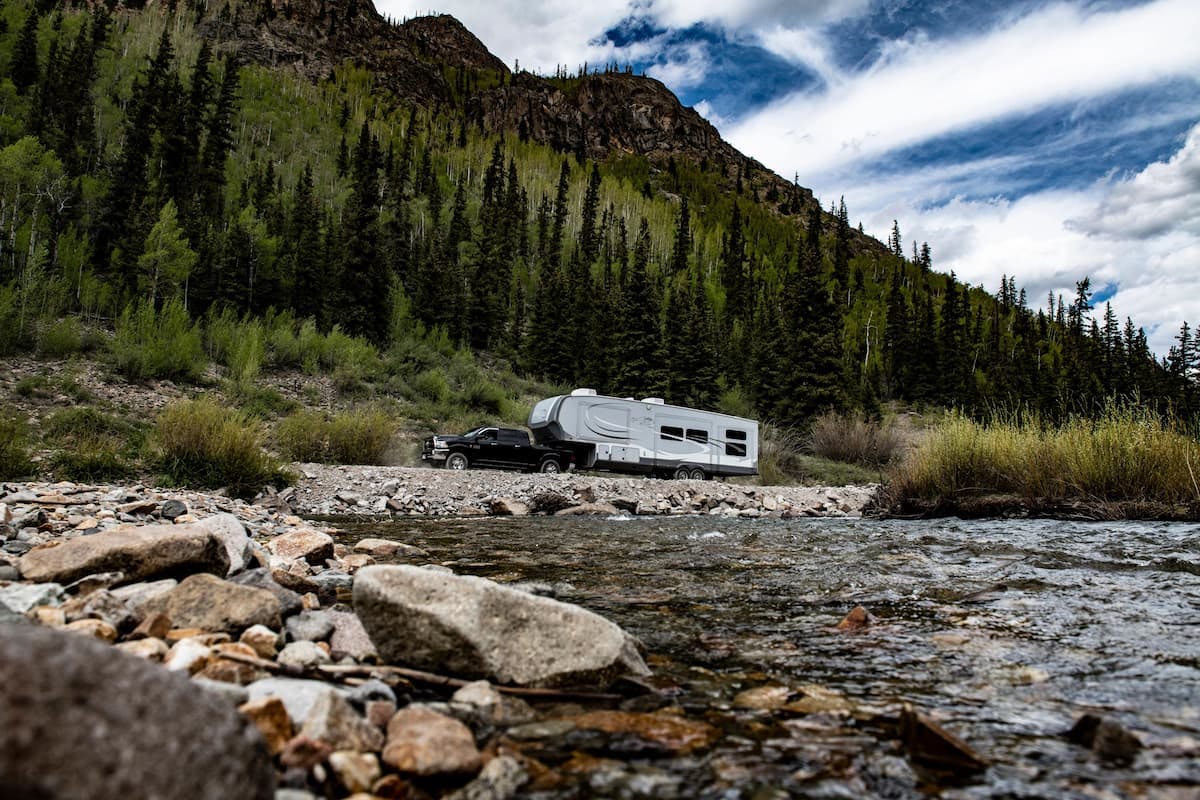 The Carew's RV driving next to a river.