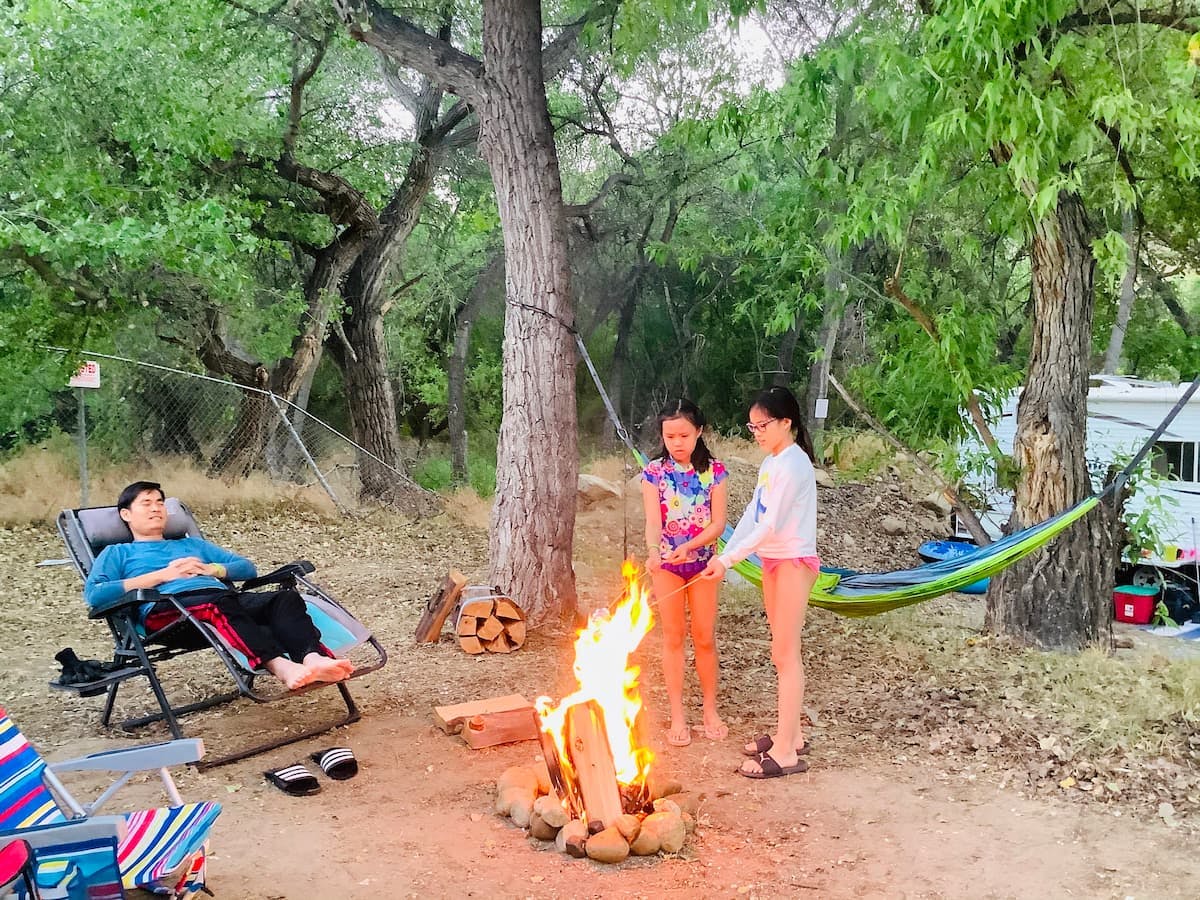 Brenda and Tiger's daughters roasting marshmallows by a campfire.