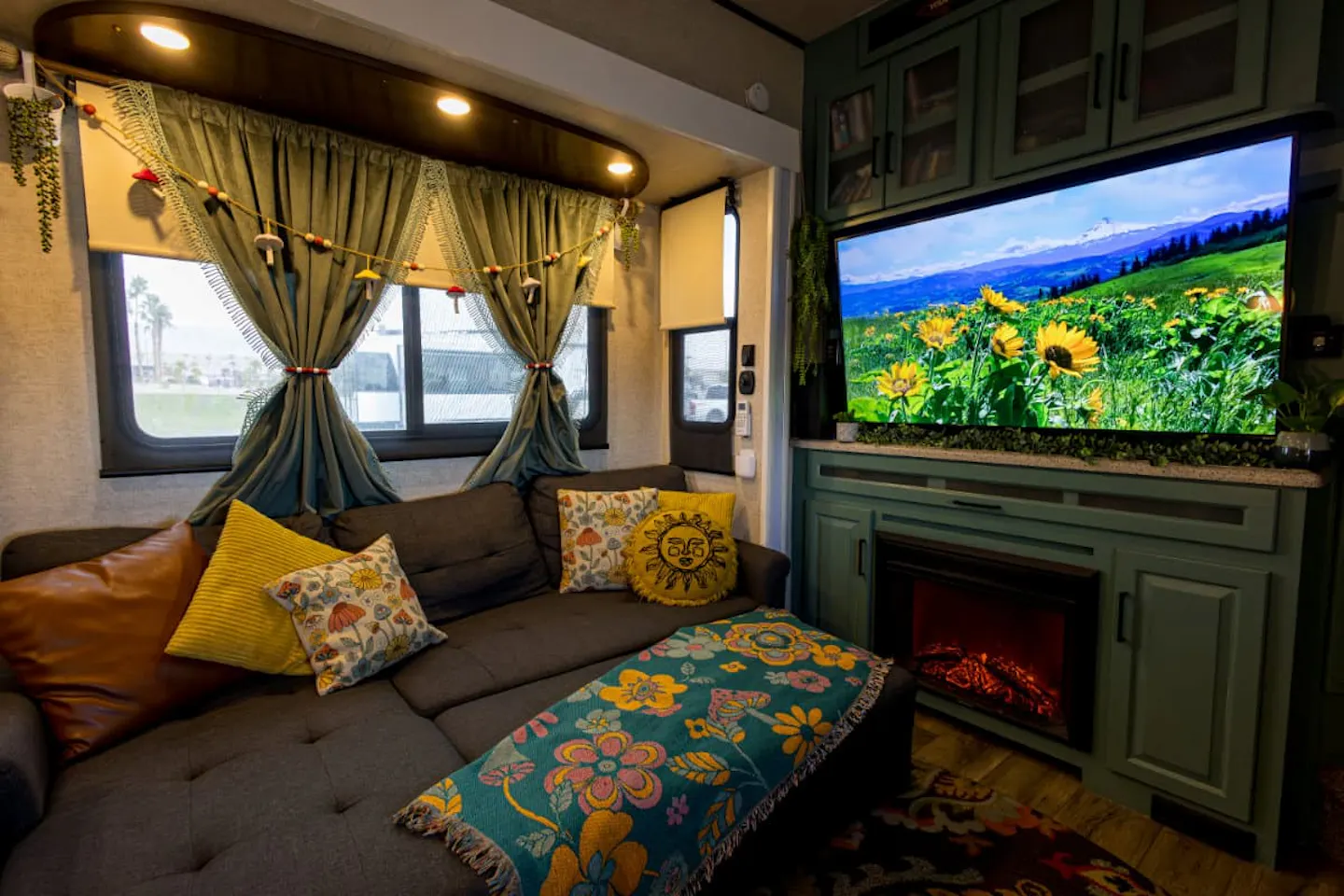 The Saul's living room in their RV with sunflowers on the TV.