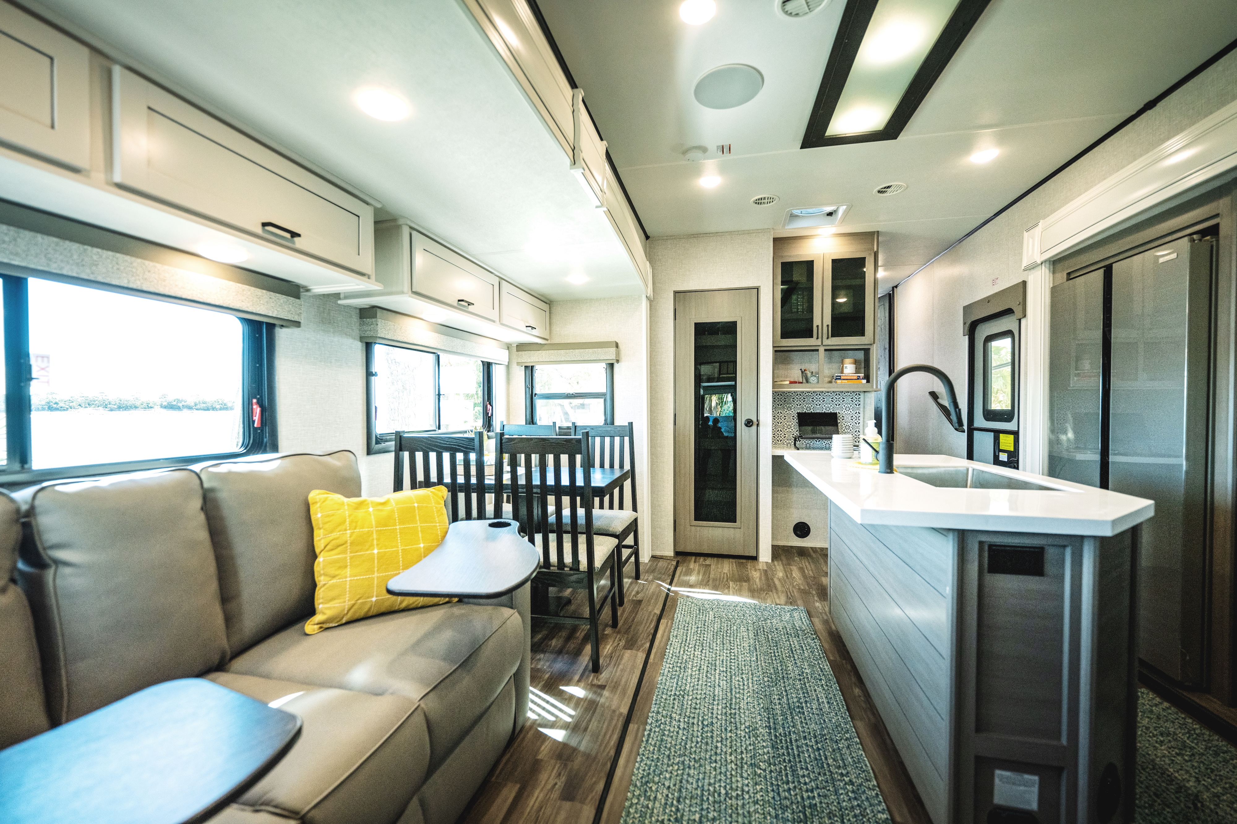 The living room and kithen of a Starcraft fifth wheel with a large couch and dinette.