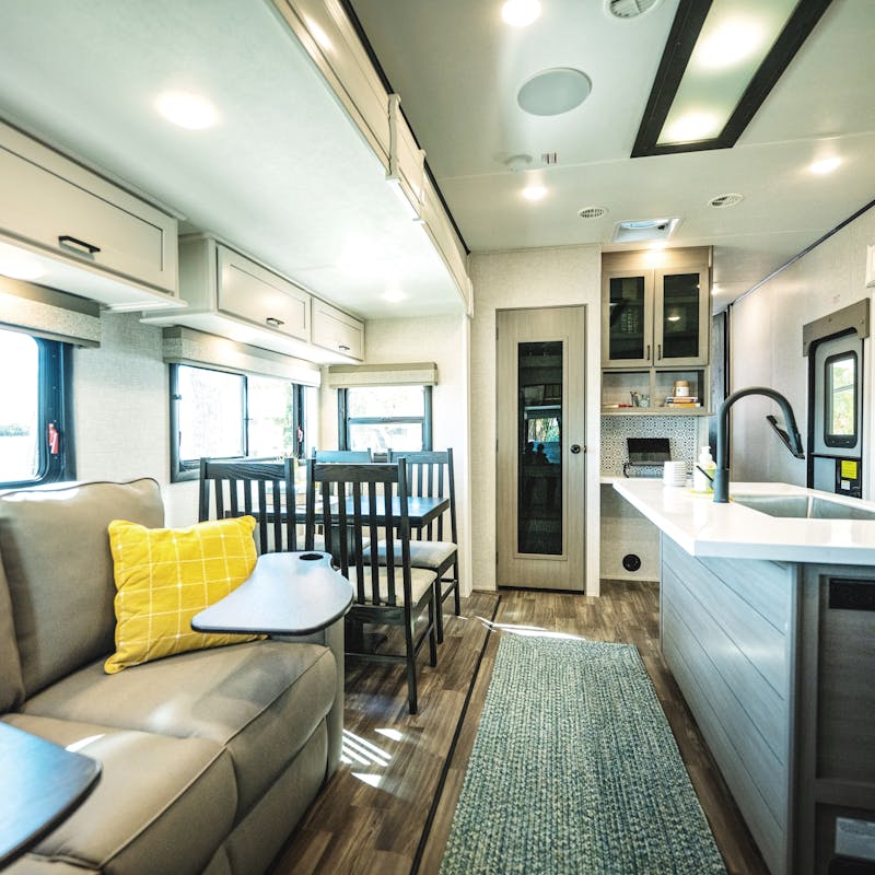 The living room and kithen of a Starcraft fifth wheel with a large couch and dinette.