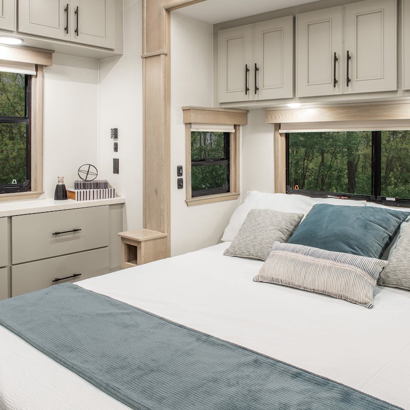 A large, clean bedroom in a DRV mobile Suites RV