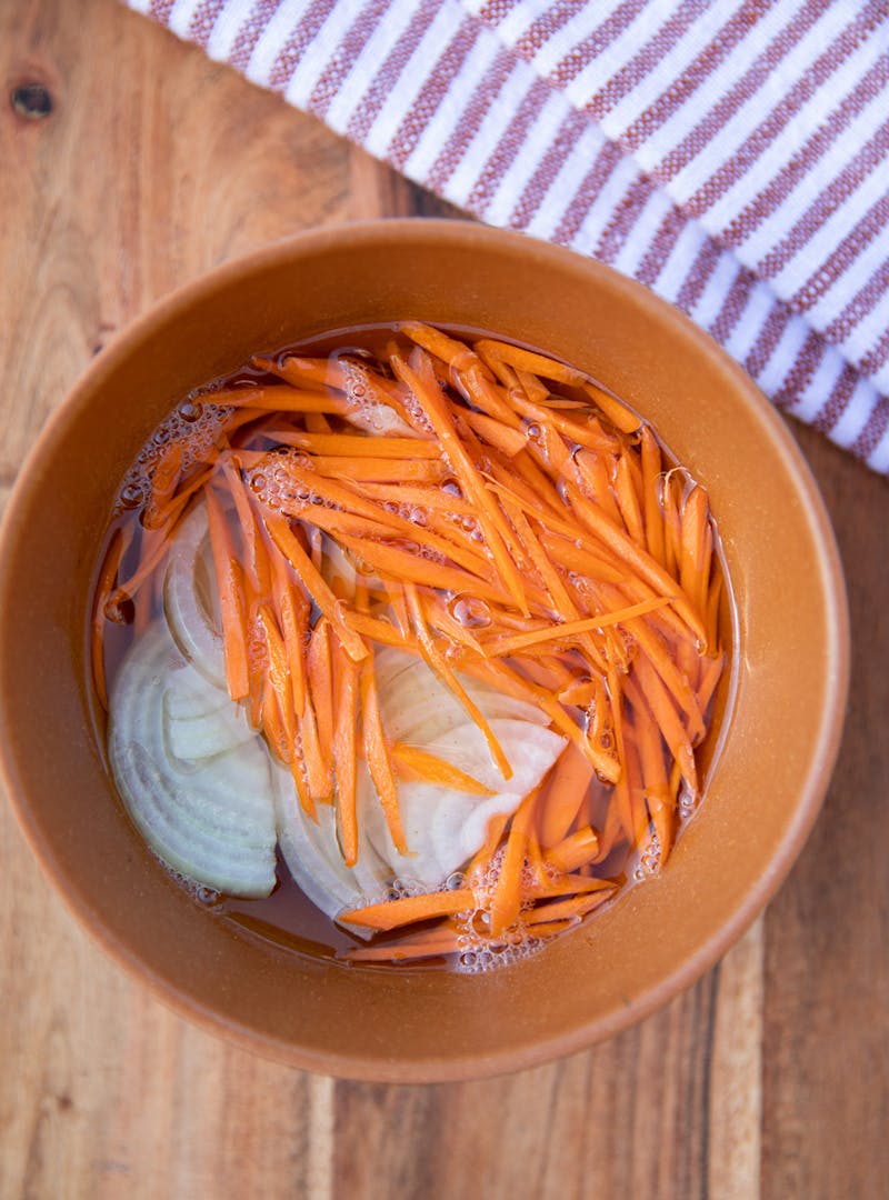 Carrots and onions pickling in a bowl.