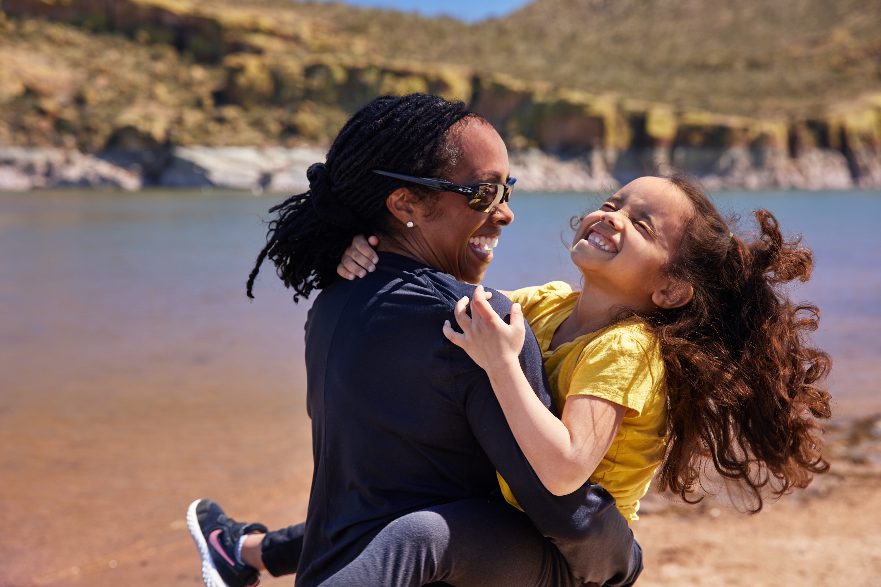 Robin spins her granddaughter around near a lake. 