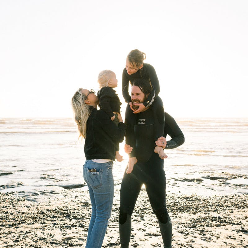 Amber Thrane and her family on the beach, with the water behind them.