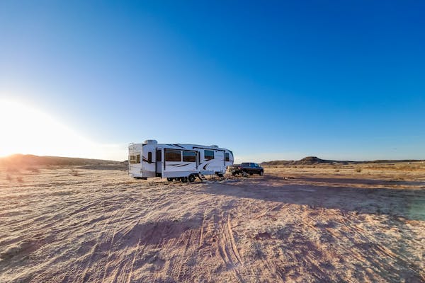 STEVE & KAYLEE TECHAU boondocking in their fifth wheel rv in a sandy landscape