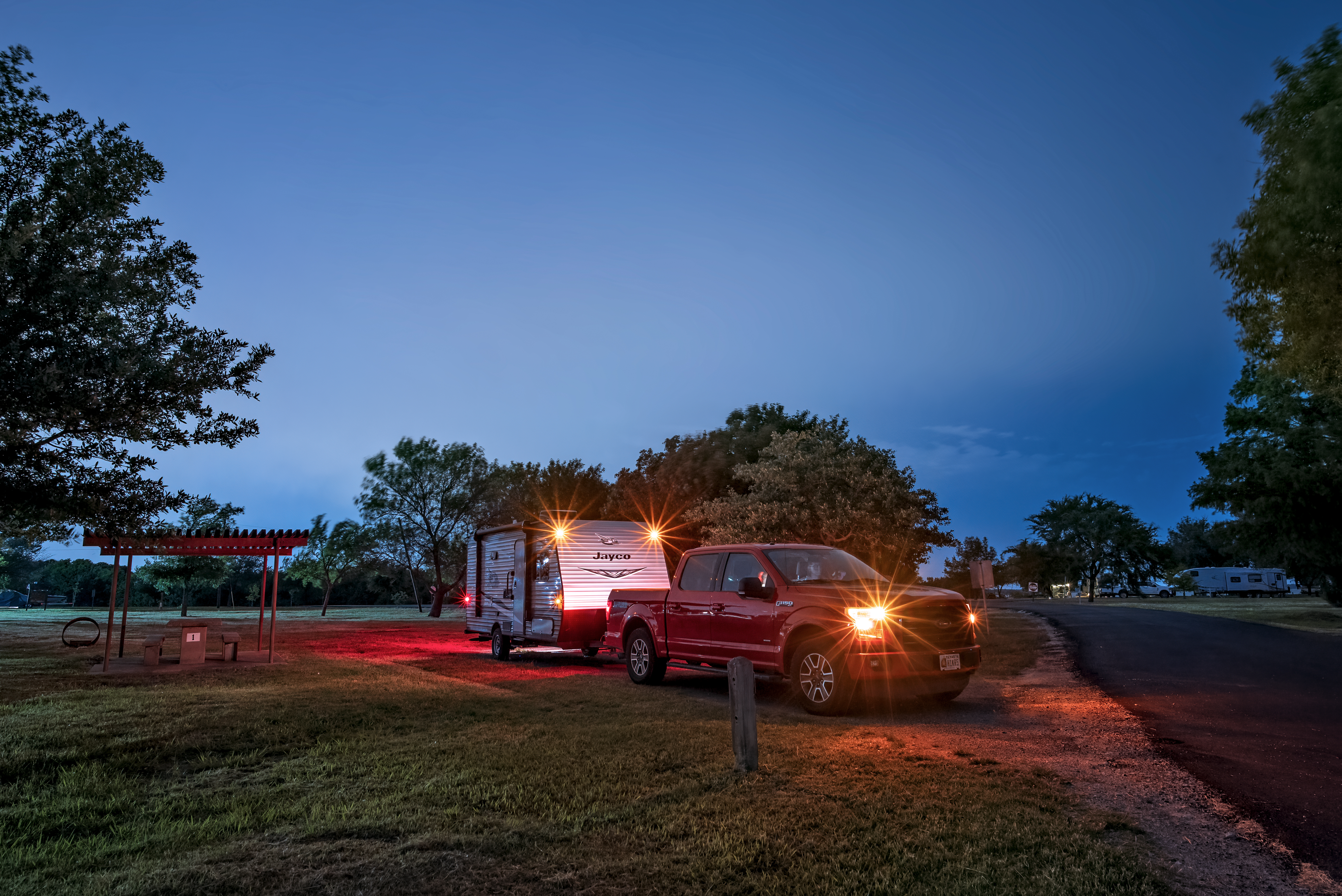 Jason Takacs parking his vehicle and jayco travel trailer at a campsite at night