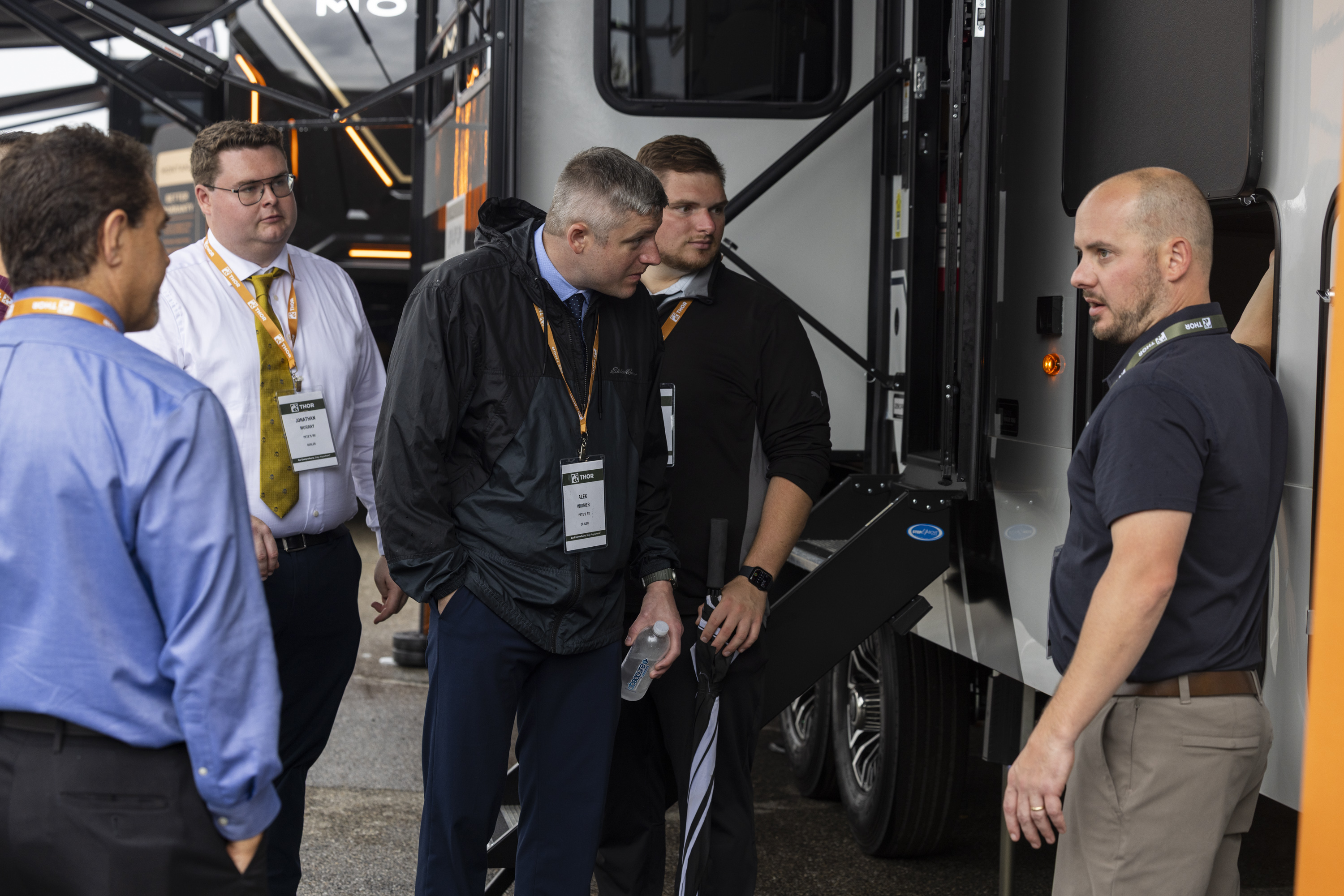 an RV salesman showing off features of an RV to dealers 