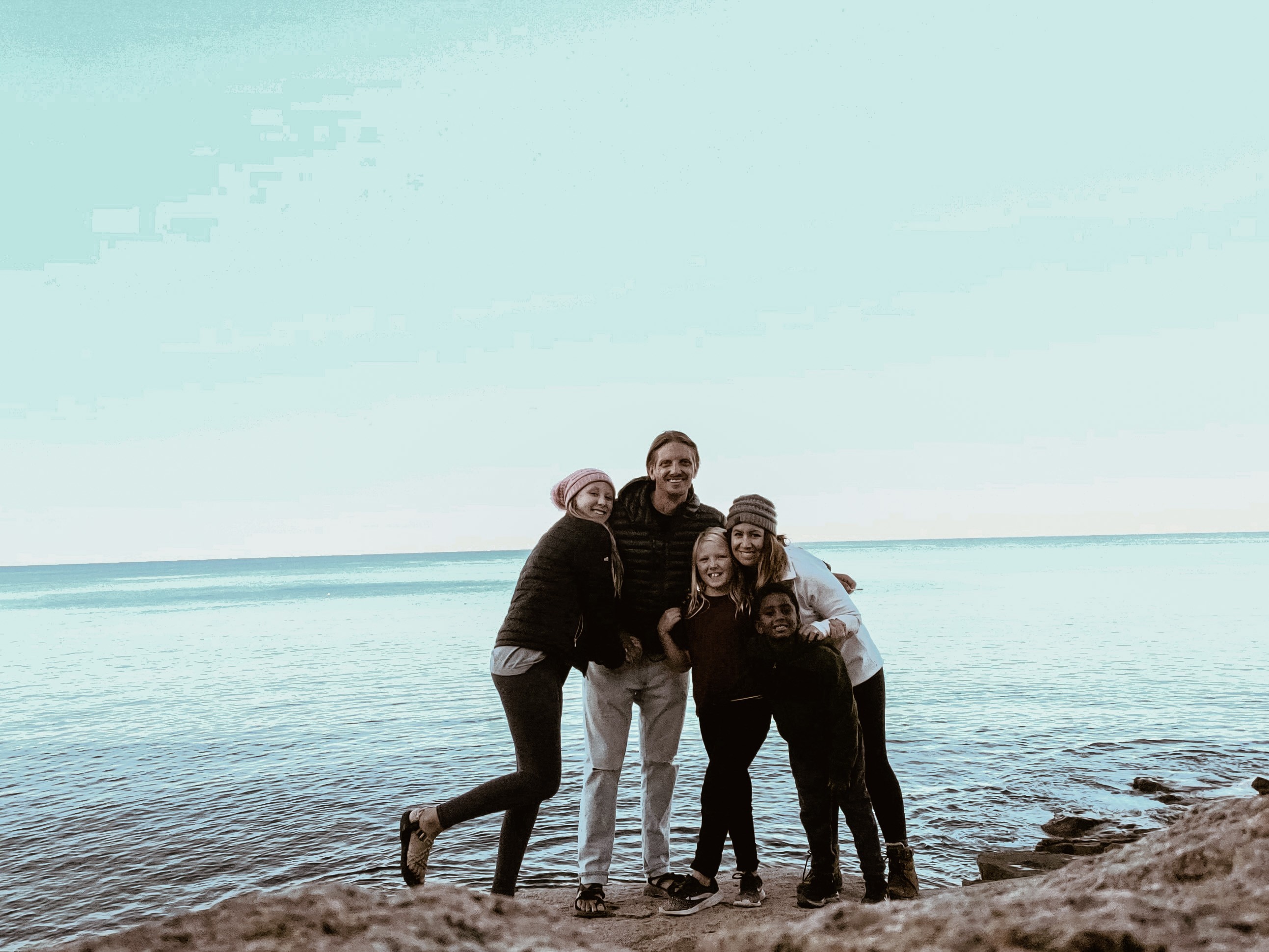 A group shot of Shannon Carew's family standing in front of a lake.