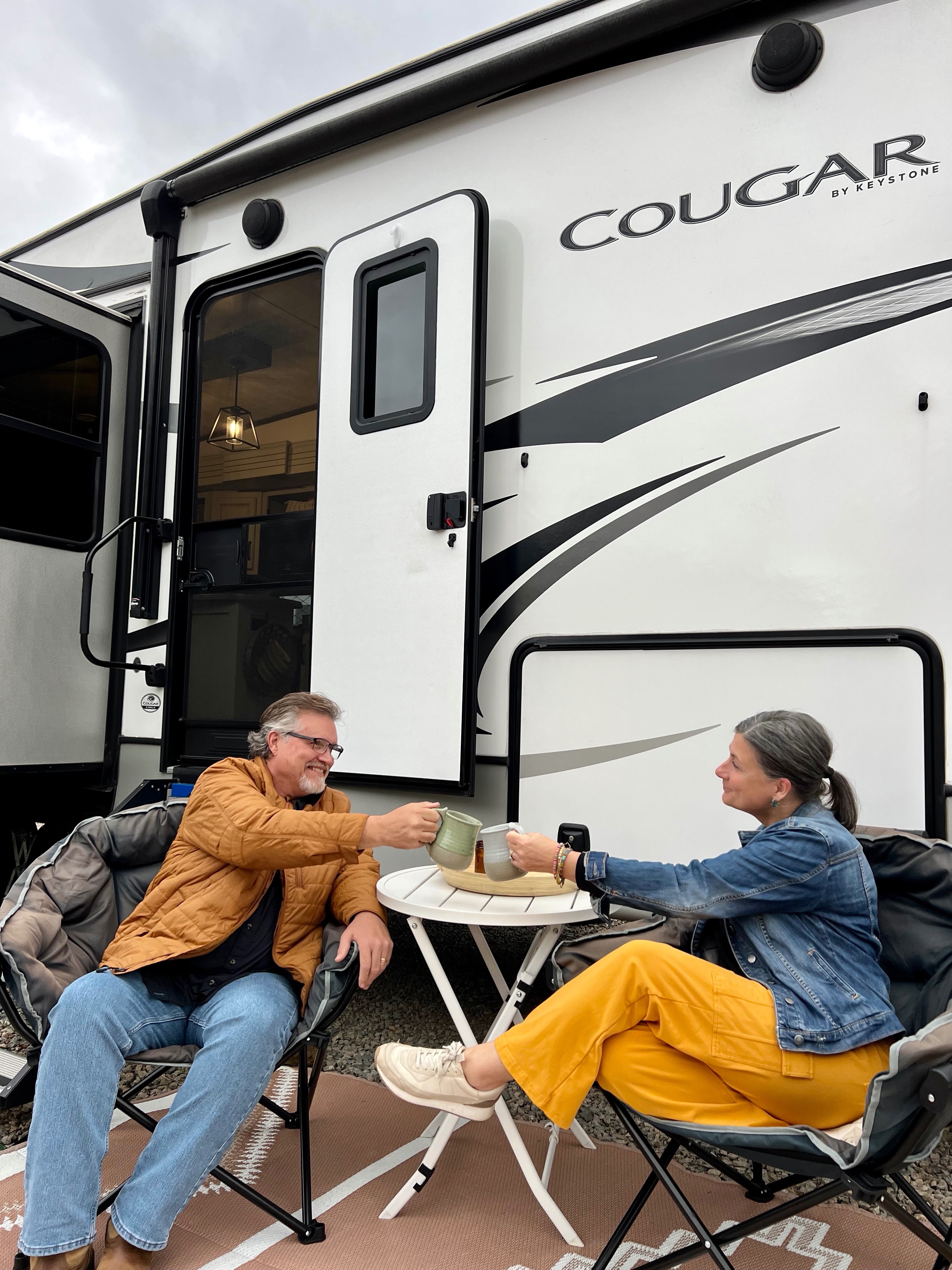 Donny and Tammy Benedict make a toast outside of their Keystone Cougar.