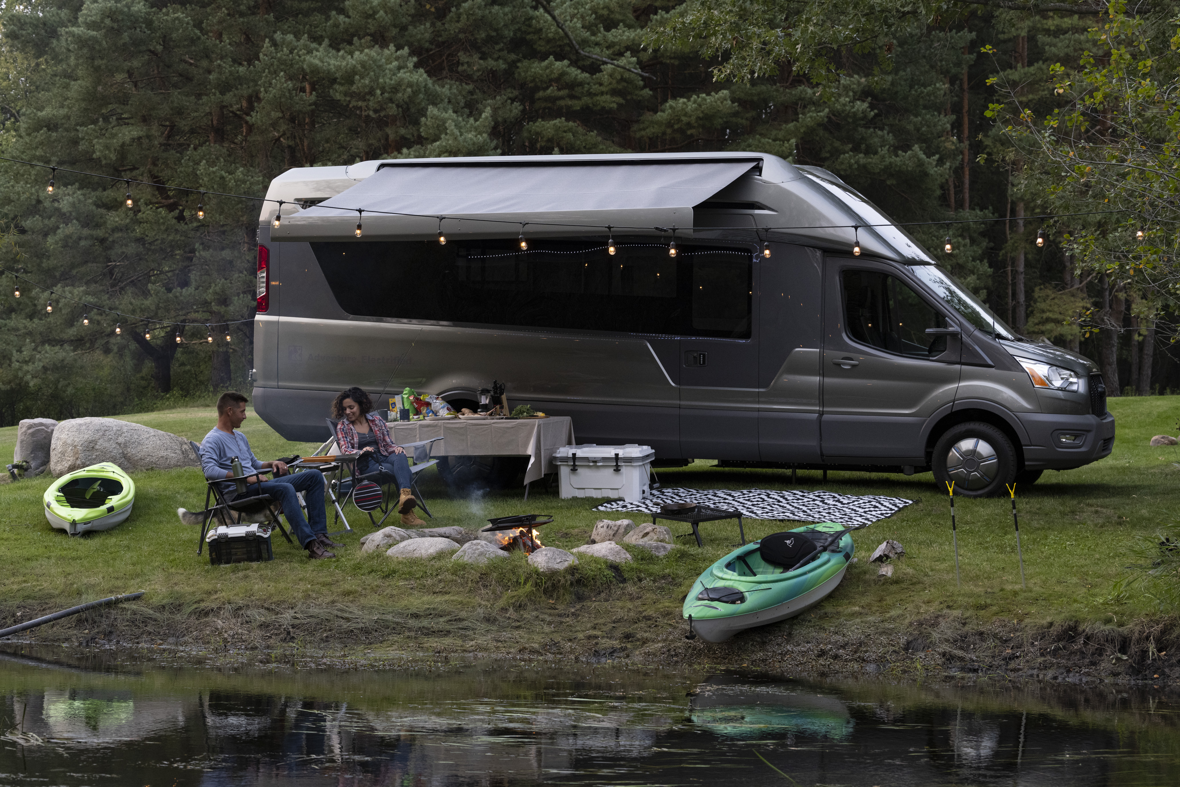 A couple camping by a lake next to the THOR vision vehicle 