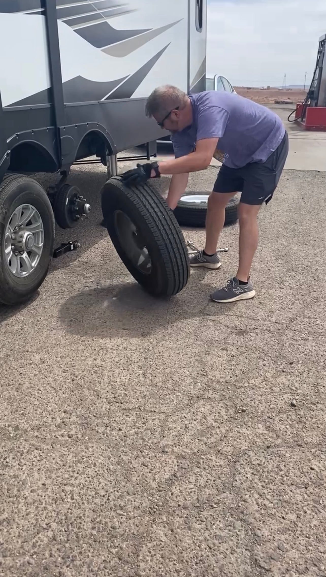 Darren Bone changing a tire on their fifth wheel