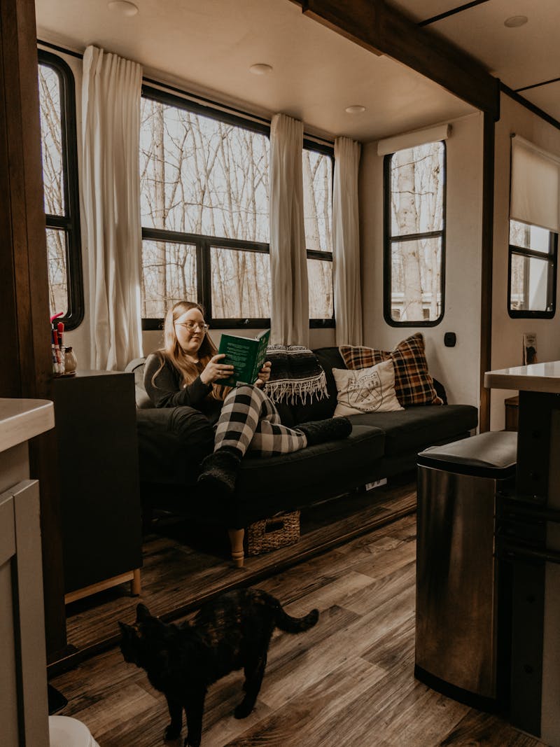 Kristin Murphy reading a book on her couch inside her Keystone RV