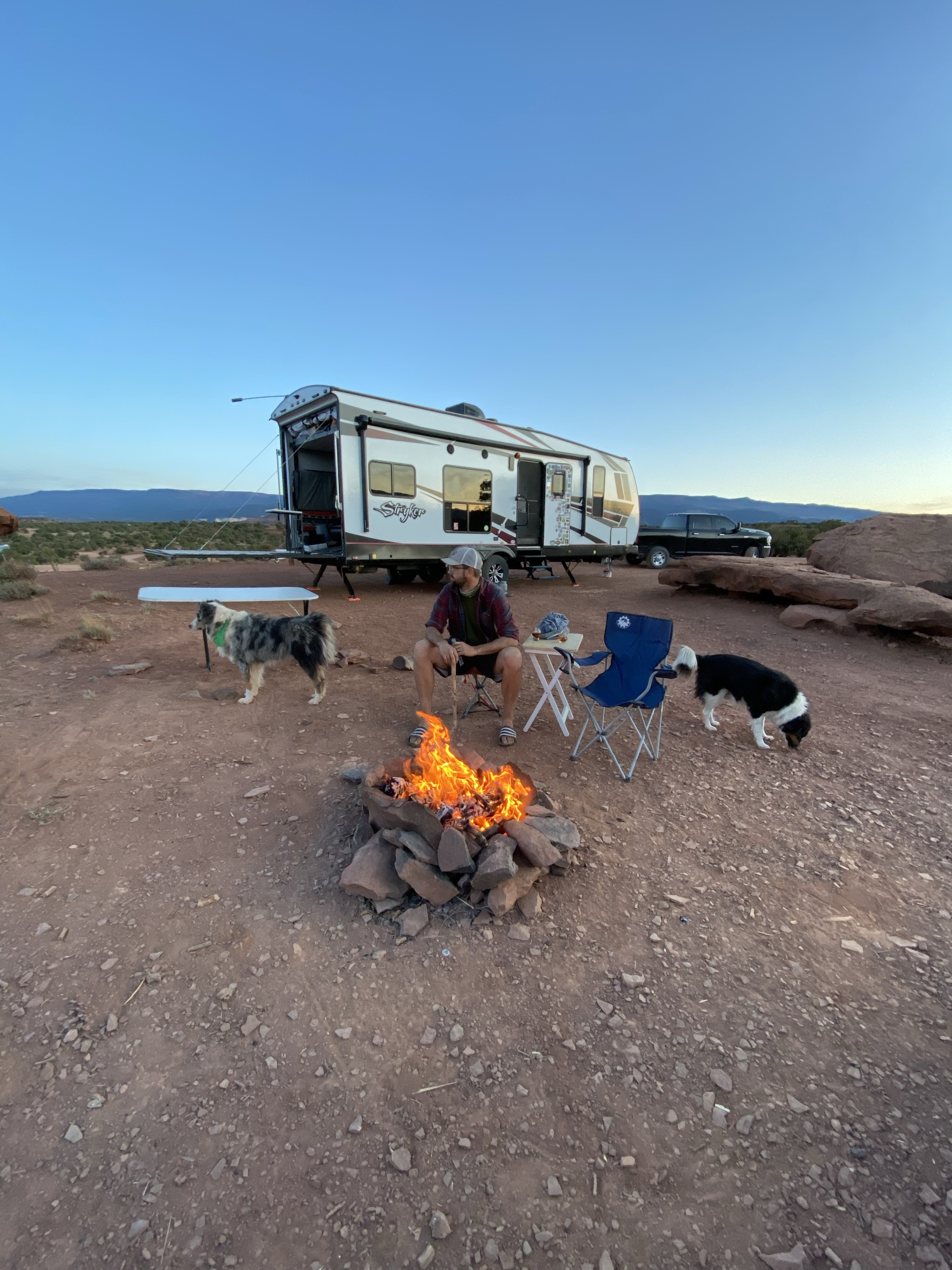 Amy Rekart's husband Mathew sits by a bonfire in front of their Cruiser Stryker toy hauler. 