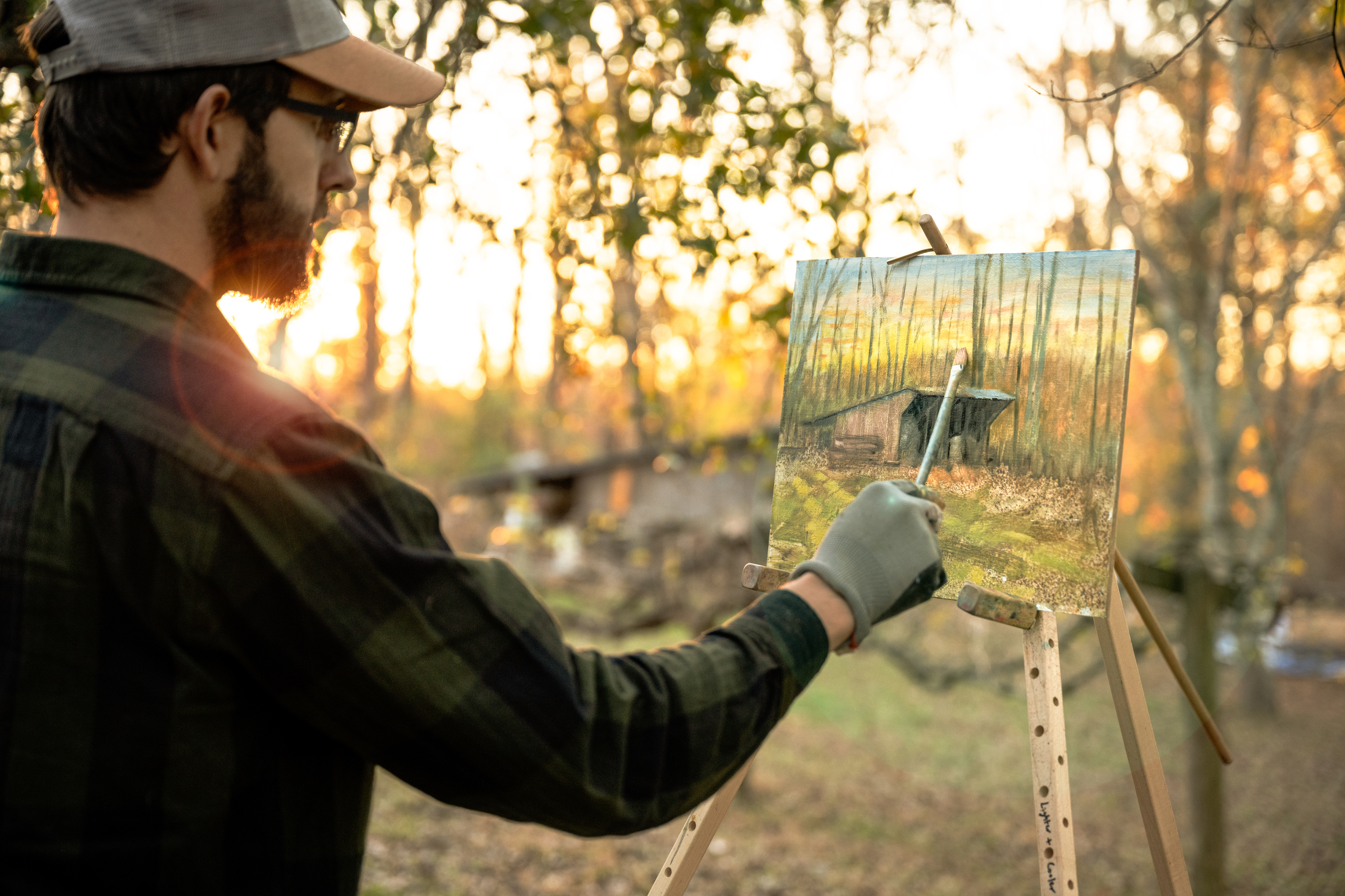Todd Schabel paints a landscape of an old barn outside as the sun rises.
