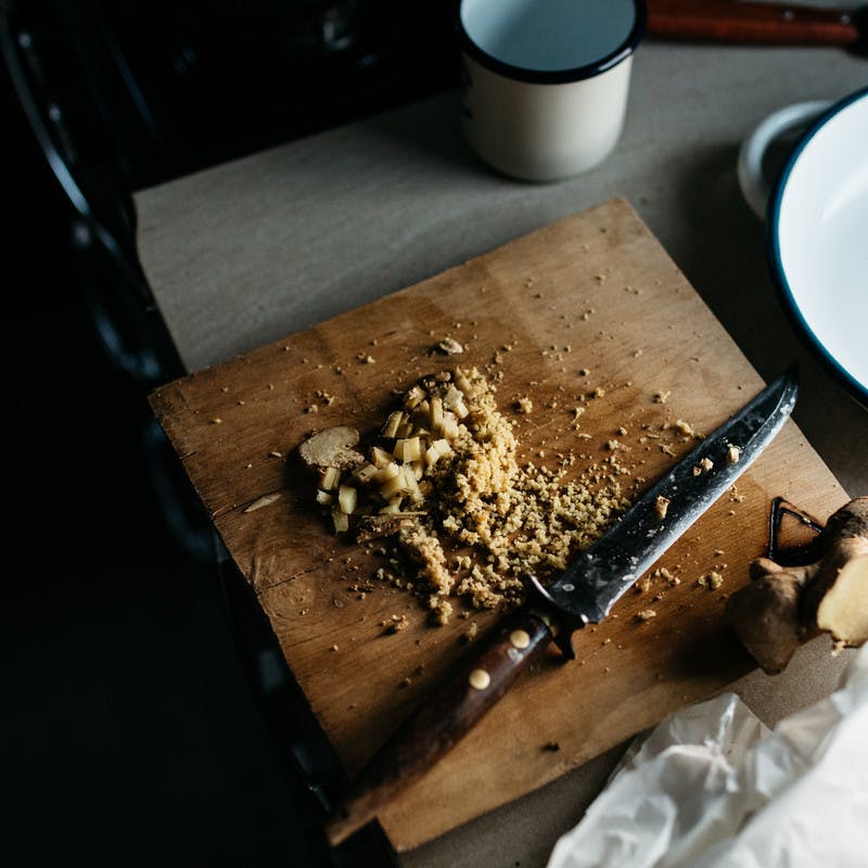 Close up of freshly chopped ginger on a cutting board.