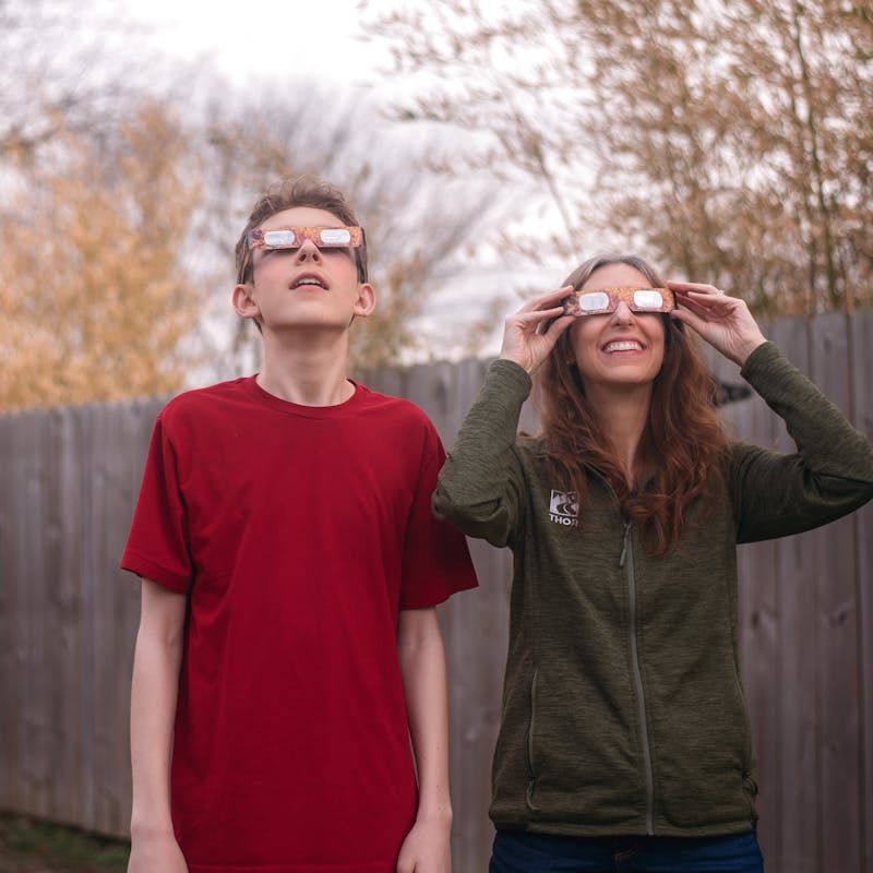 Alison Takacs using solar glasses with her son