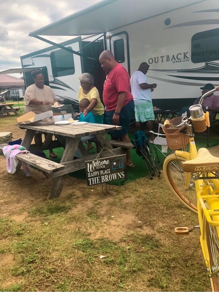 A family sets a picnic table outside of their RV.