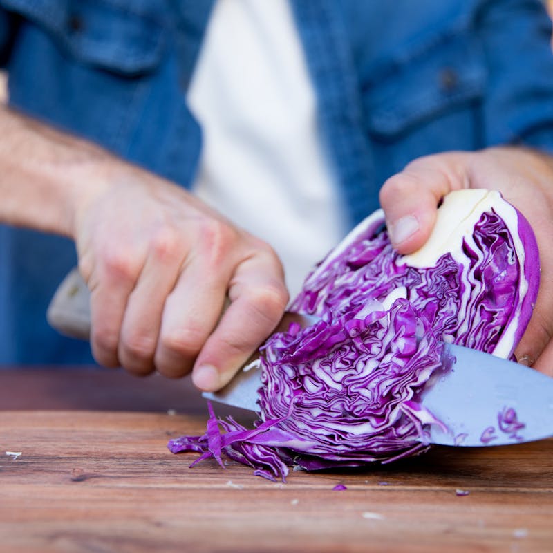 A man cuts cabbage.