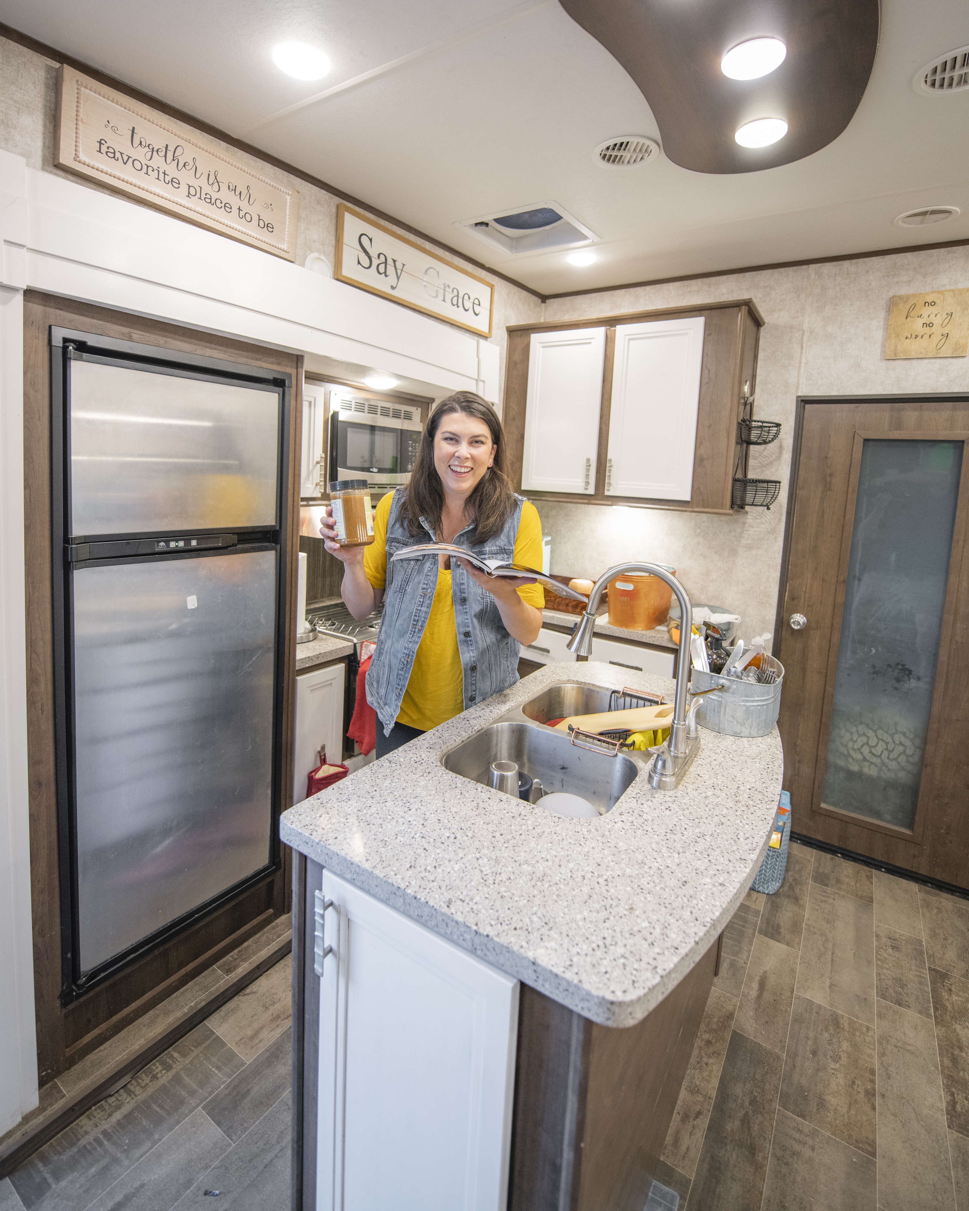 Chelsea Day holding a cookbook in her highland ridge rv.